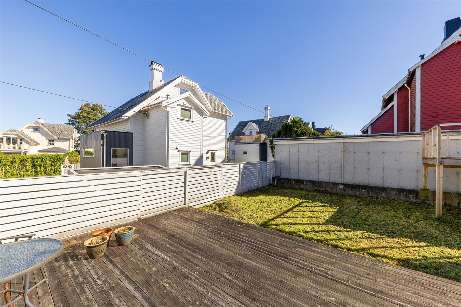 Terrassen har et romslig tredekke som gir god plass til utemøbler. Gressplen og gjerde skaper et privat og skjermet uteområde. Galleribilde