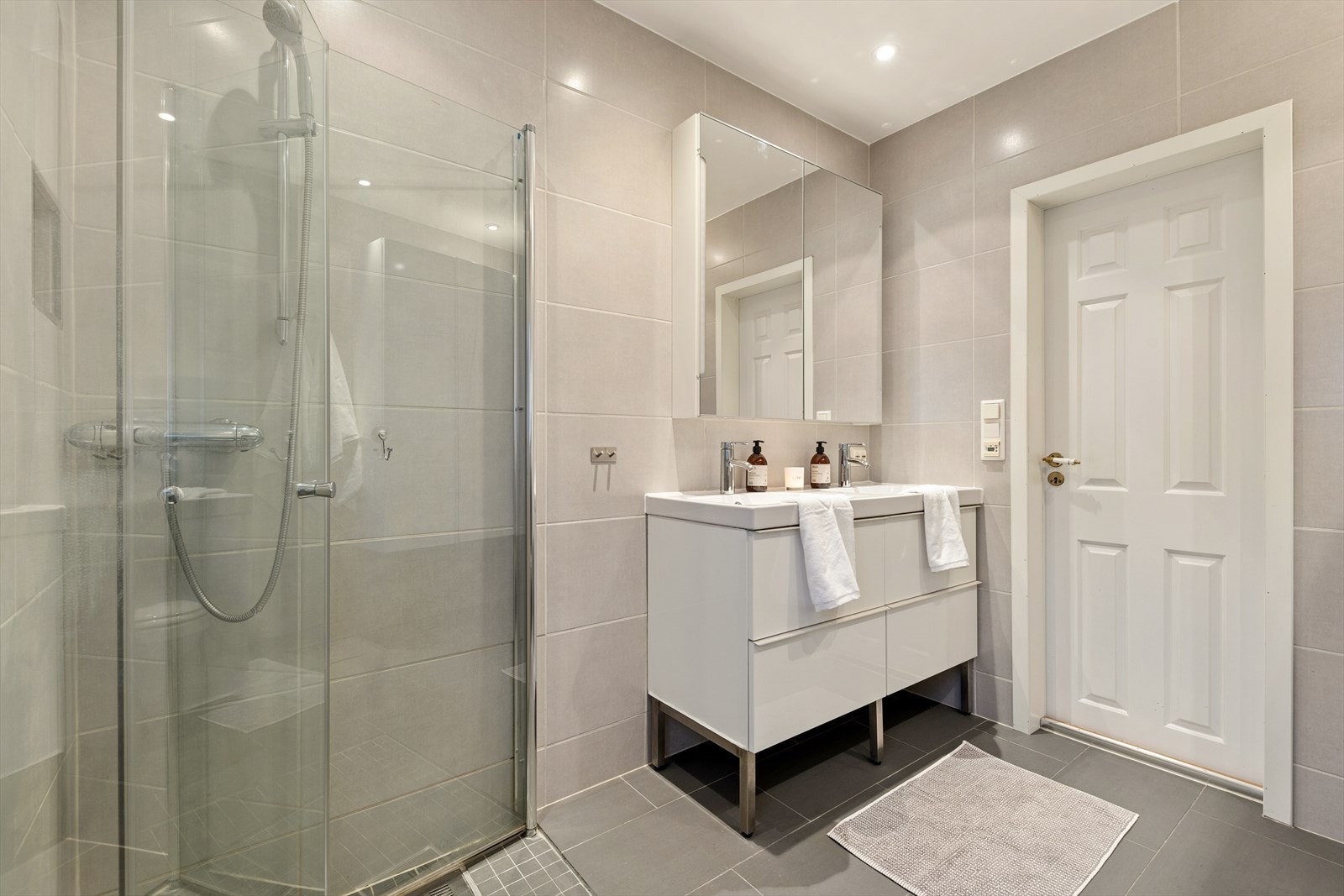 Baderommet er utstyrt med flislagte vegger og gulv som har elektriske varmekabler for et moderne bademiljø. Galleribilde