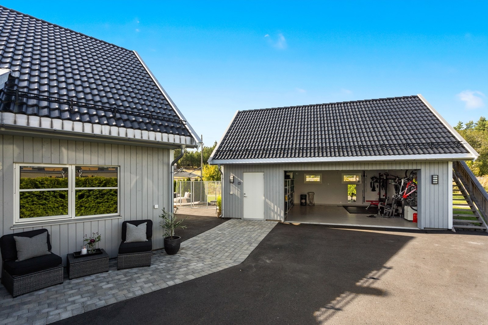 Til eiendommen hører en frittstående dobbelgarasje fra 2022 med innredet rom i andre etasje. Asfaltert gårdsplass. Galleribilde