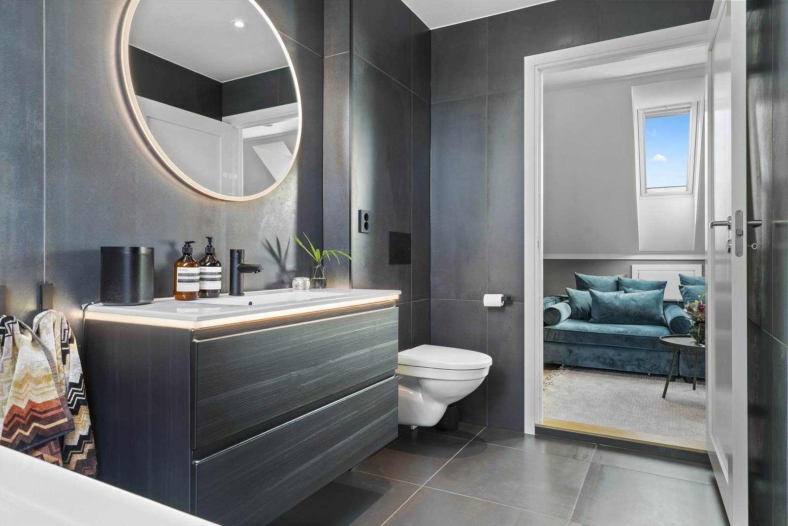 Rommet har en moderne innredning med servant, speil med integrert lys og vegghengt toalett. Galleribilde