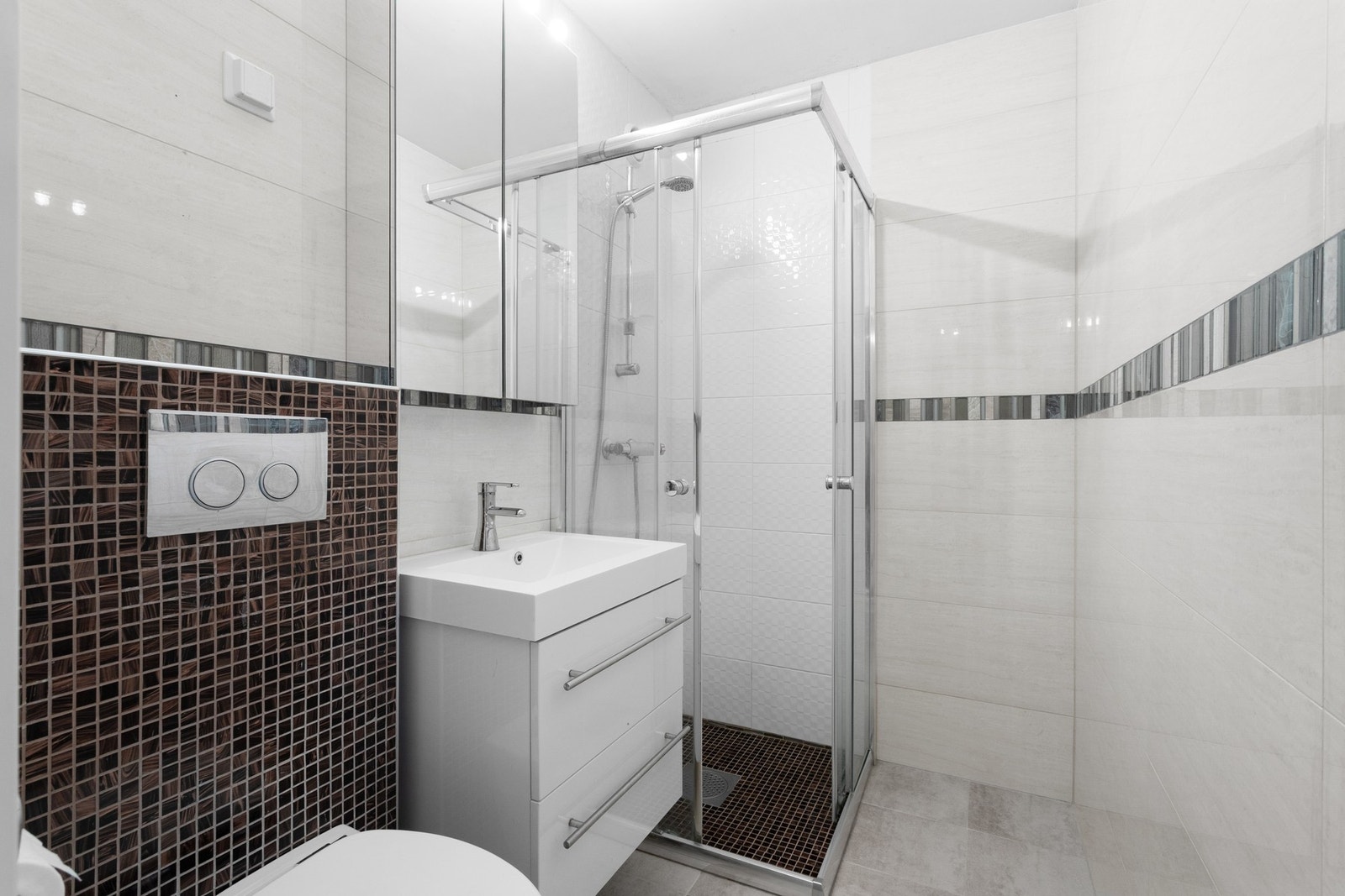 Pent flislagt bad fra 2013. Rør/el-arbeid er utført av håndverker. Dusjhjørne, servant med underskap og speilskap. Veggmontert WC. Galleribilde