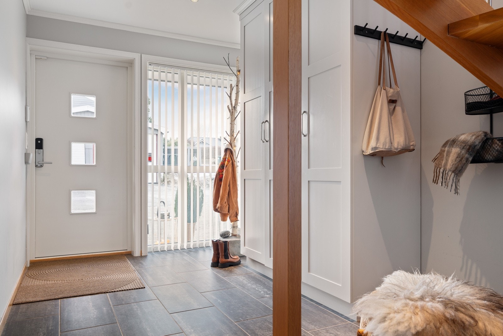 Lys og stilren entré med plassbygd garderobe som gir rikelig med oppbevaringsplass til sko og ytterklær. Galleribilde