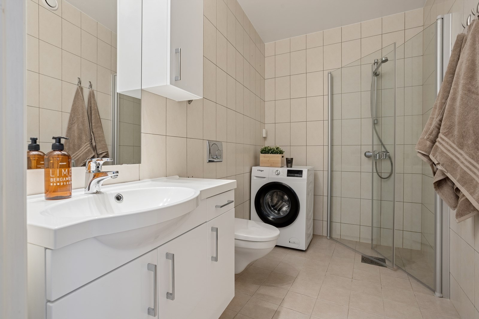 Pent, helfliset bad med varmekabler i gulv og opplegg for vaskemaskin. Galleribilde