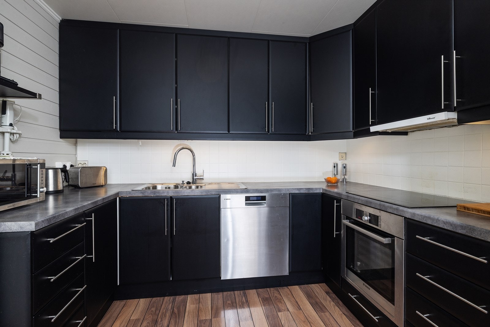 Kjøkkeninnredning i U-form gir rikelig med skap- og benkeplass, med integrert stekeovn og platetopp. Galleribilde