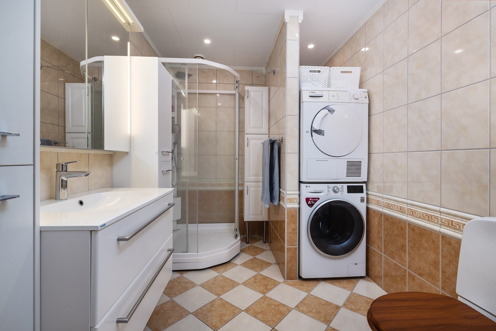 Badet har stort 100x100 dusjkabinett og praktisk opplegg for vaskesøyle med tørketrommel og vaskemaskin. Galleribilde