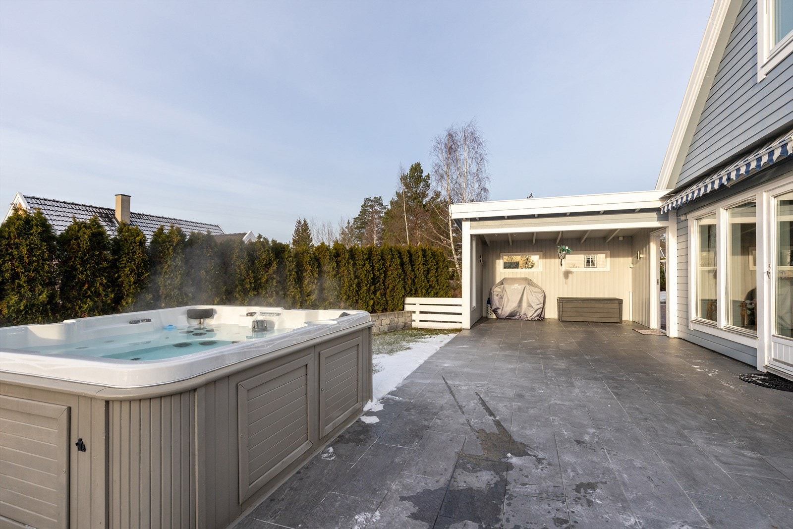 Uteområdet er skjermet og privat, med en tettvokst hekk som rammer inn eiendommen. Galleribilde