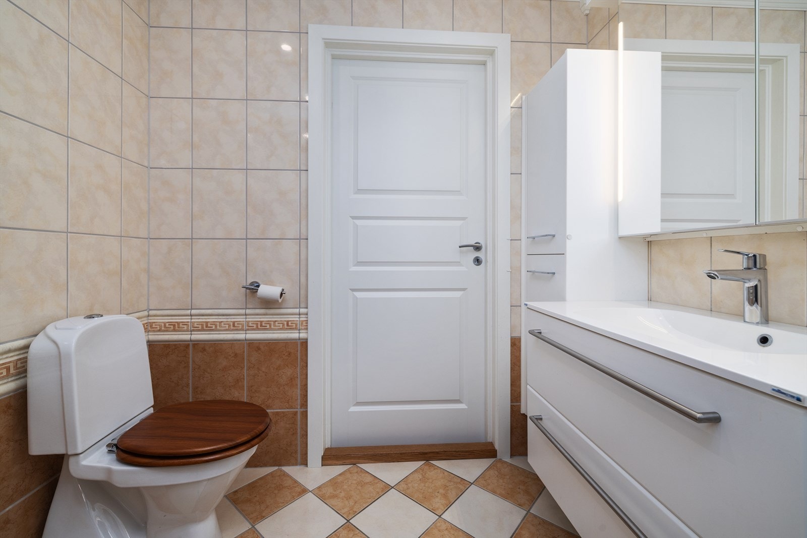 Boligens hovedbad er helfliset og utstyrt med servant i baderomsinnredning og toalett. Galleribilde