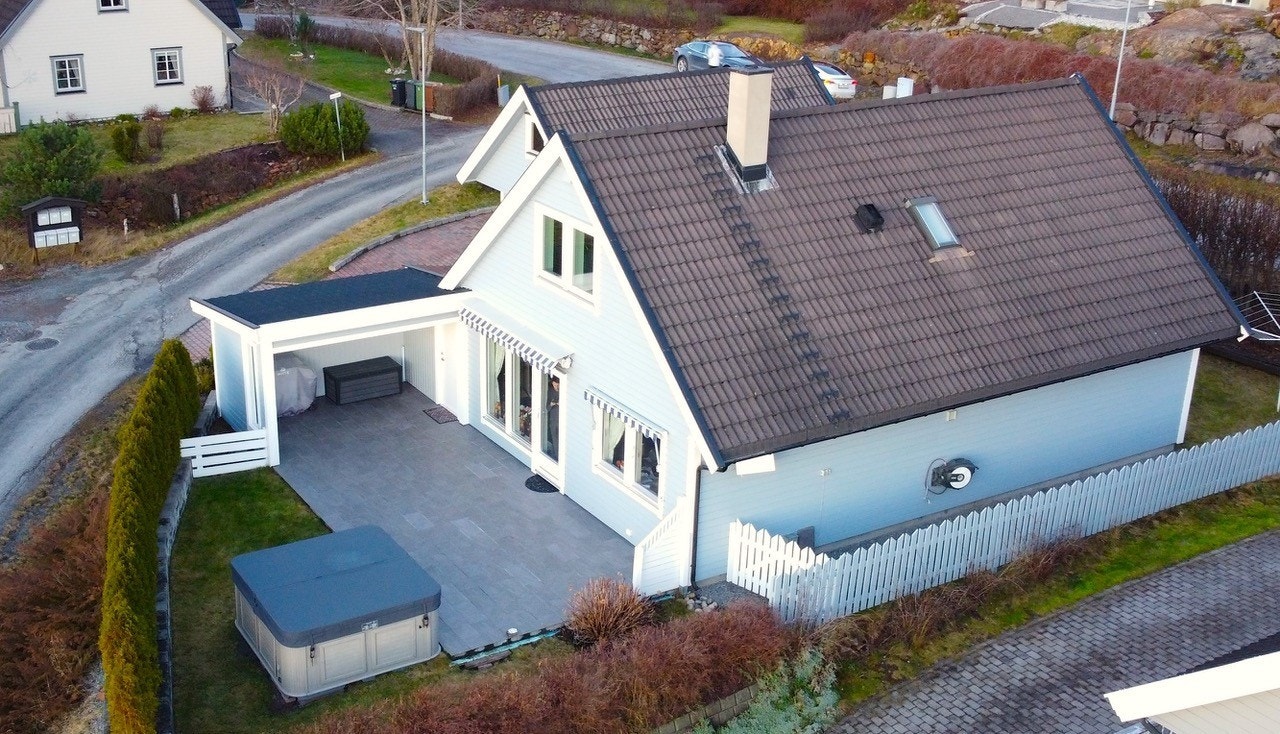 Tomten er pent opparbeidet med plen, beplantning og steinlagte flater som krever lite vedlikehold. (selgers bilde) Galleribilde