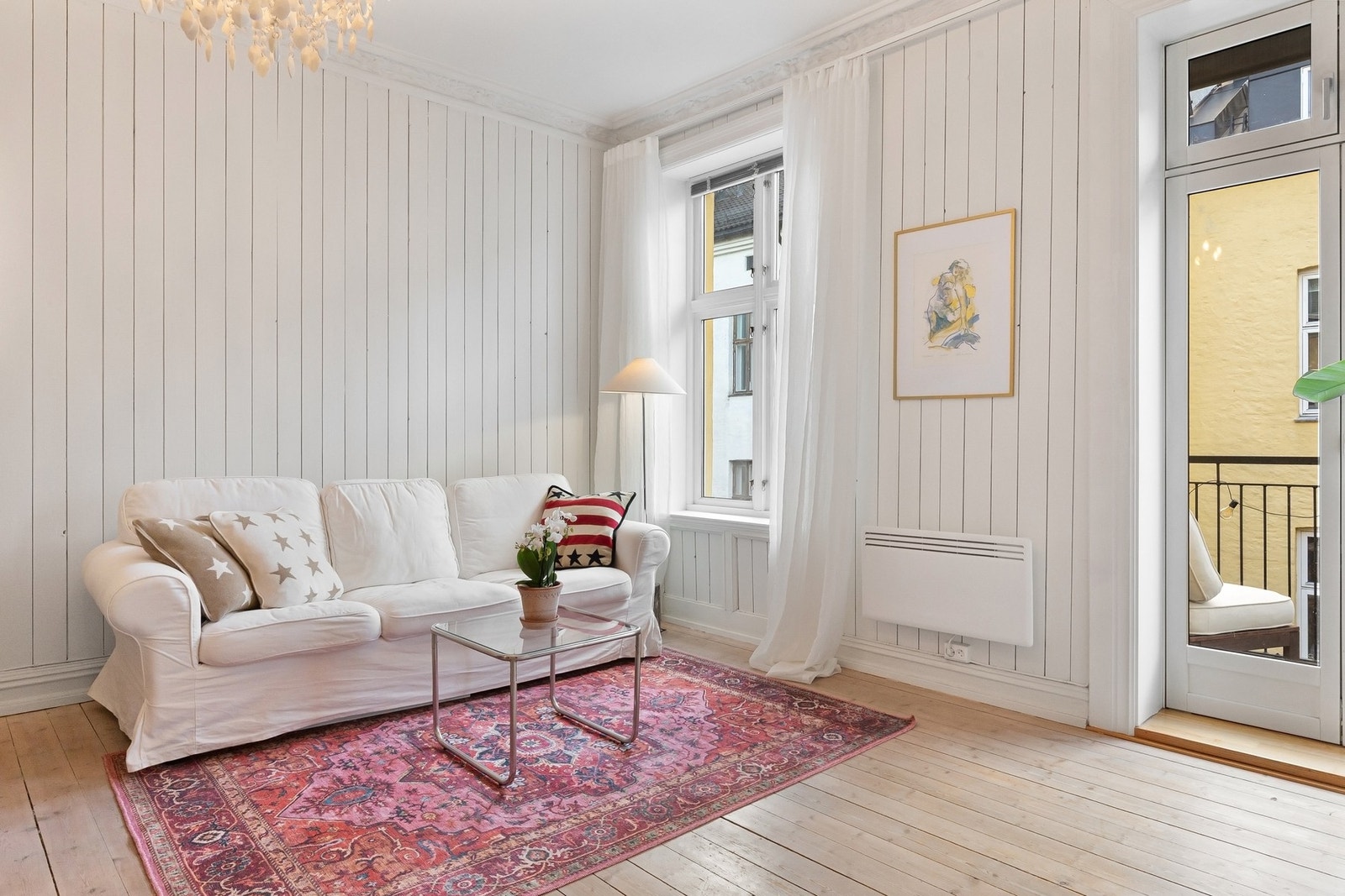 Store vindusflater og balkongdør slipper rikelig med dagslys inn og forsterker den luftige romfølelsen. Galleribilde