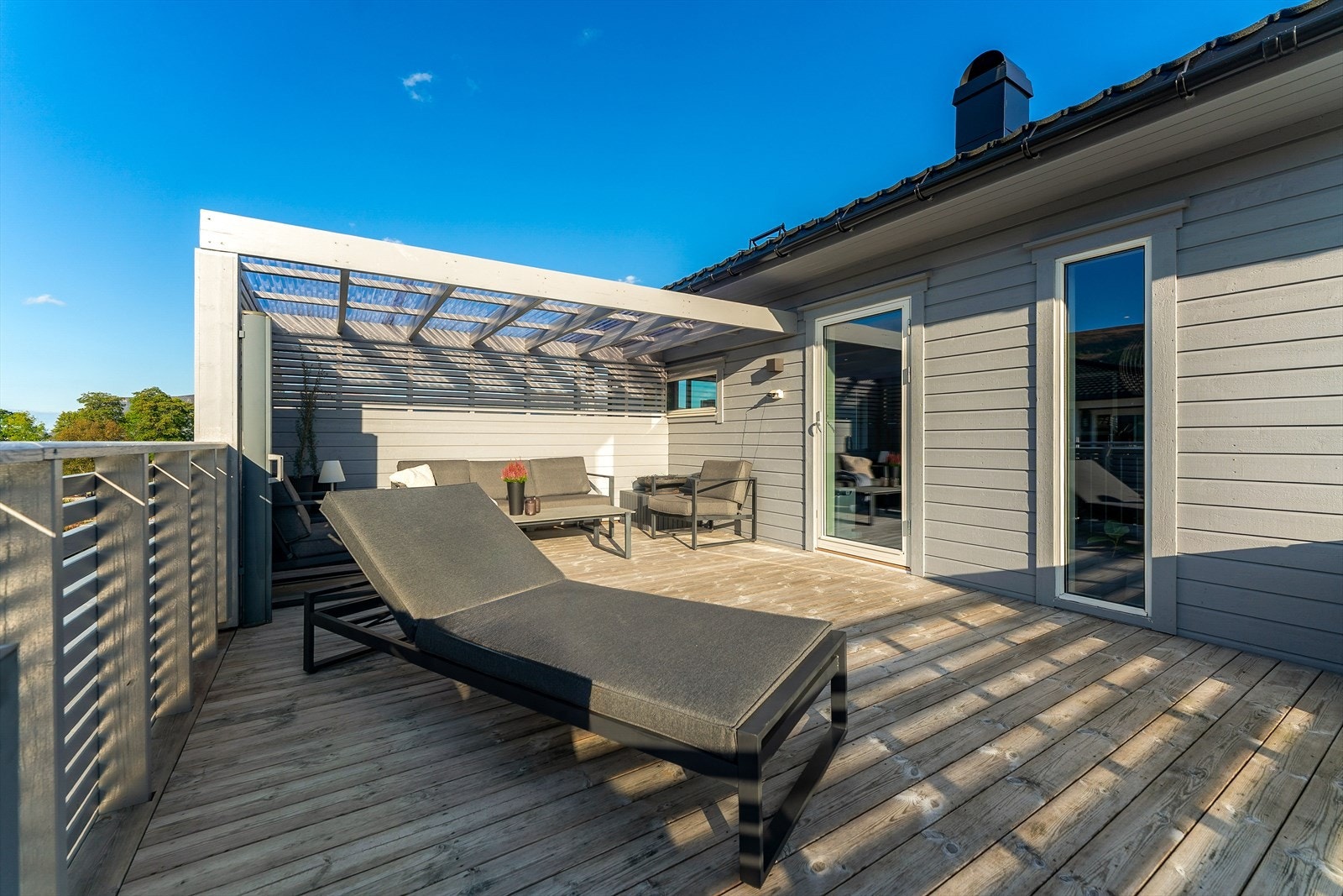 Stor terrasse som utgjer taket på carport. Utgang frå stue Galleribilde