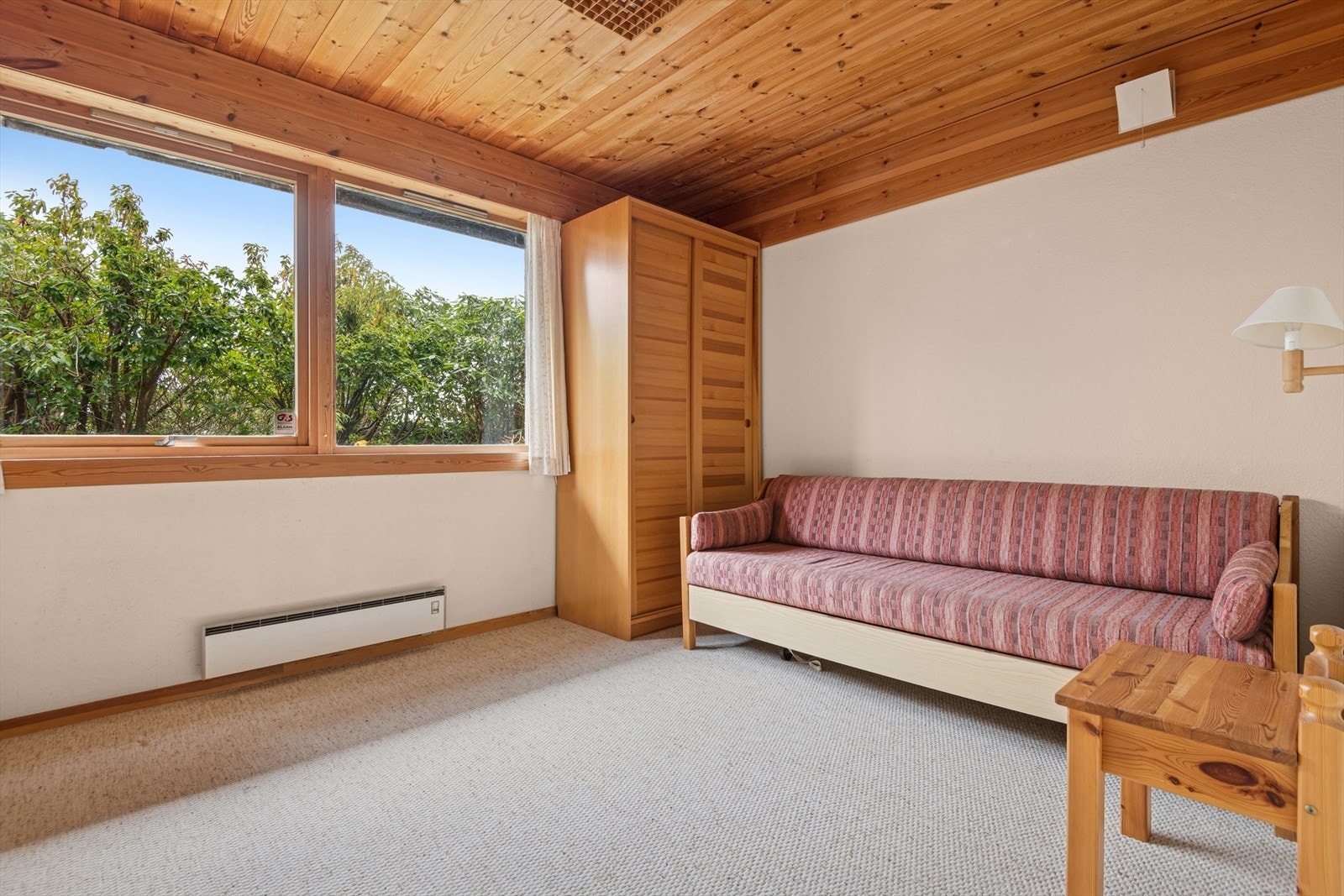 Trepanel i tak og vegger gir rommet et varmt uttrykk. Galleribilde