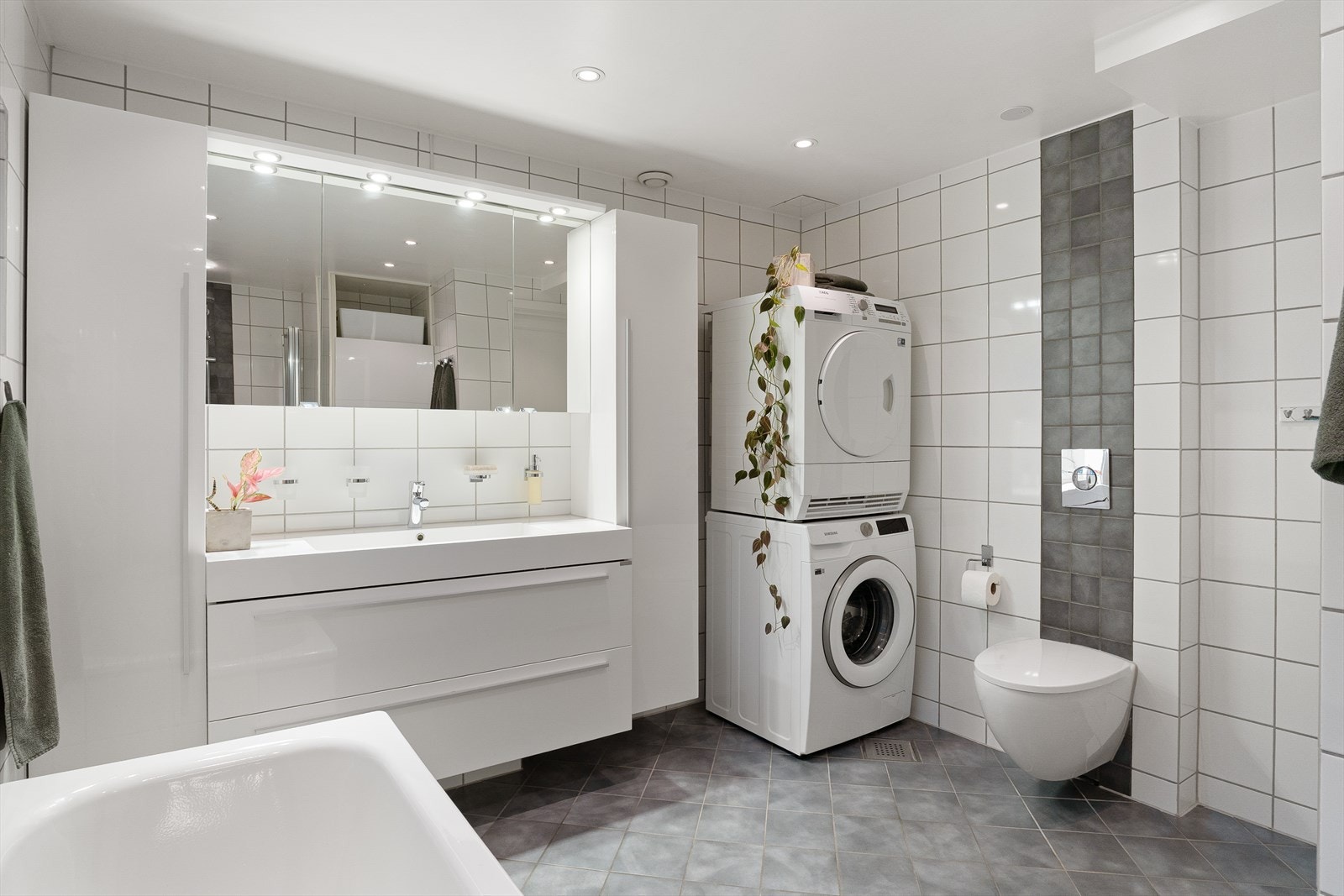 Flislagt bad/vaskerom med malte himlingsplater og innfelte downlights som gir behagelig belysning Galleribilde