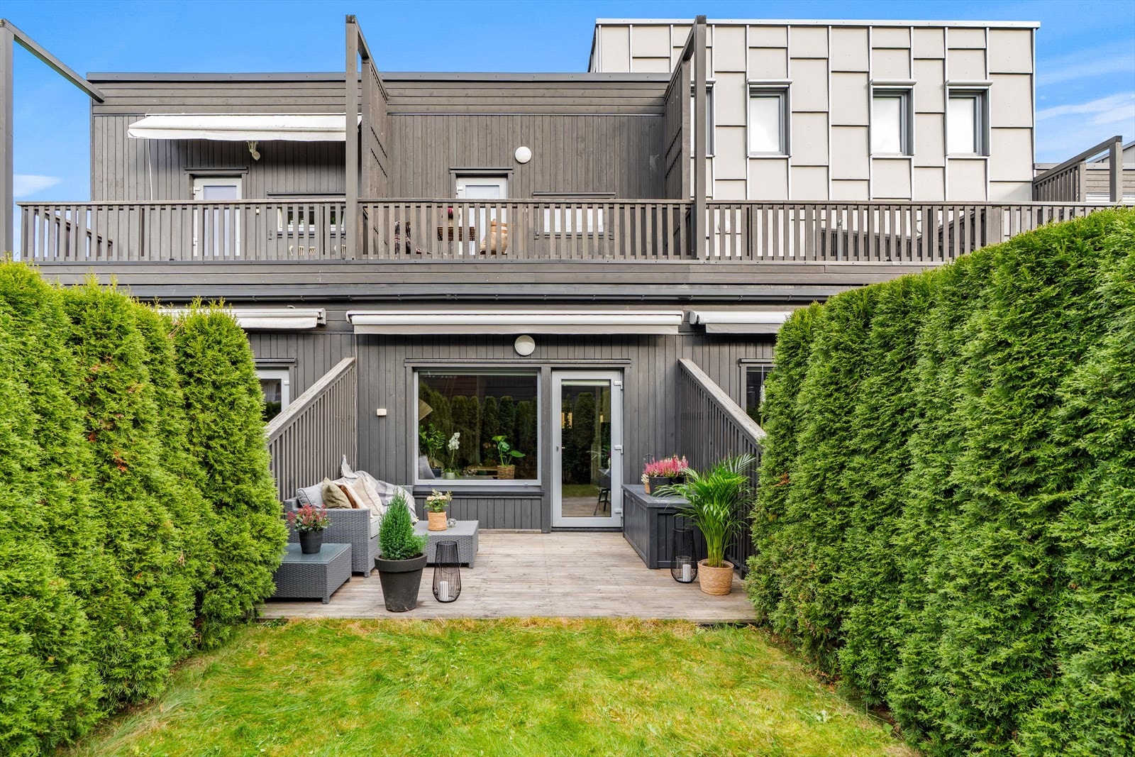 Fra stuen har du utgang til en hyggelig uteplass med platting og plen. Skjermet med thujahekker. Galleribilde