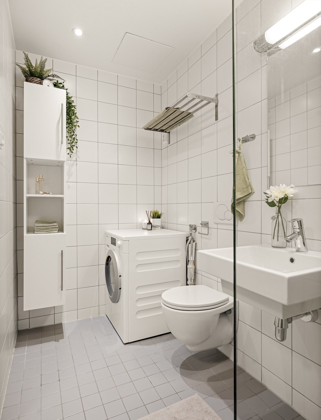 Badet er utstyrt med vegghengt toalett, servant, ettgreps blandebatteri, dusjhjørne med vegg i glass, plass og opplegg for vaskemaskin. Galleribilde