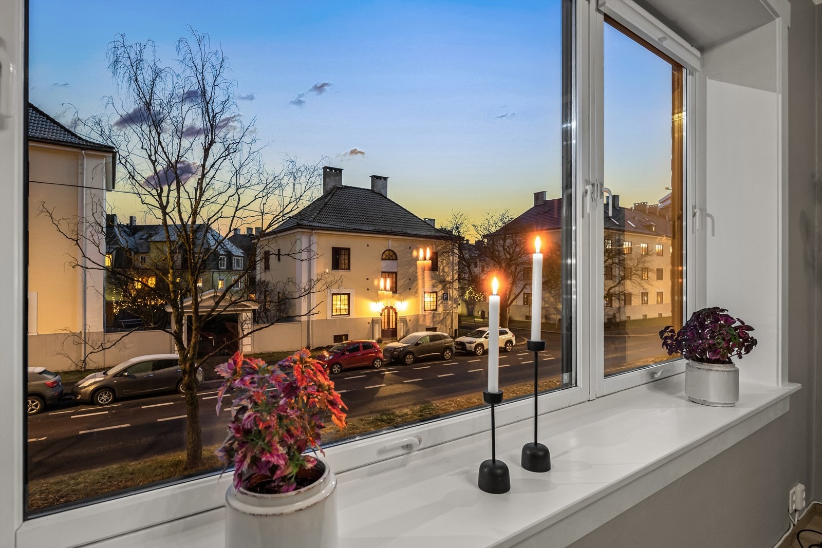 Utsikt fra stuevinduet - nabolaget er hyggelig med sjarmerende bebyggelse og frodige trær sommerstid. Galleribilde