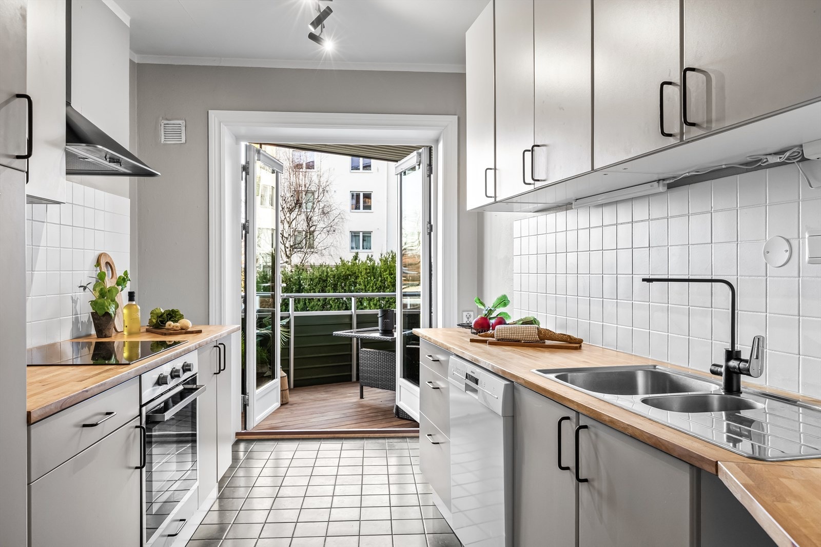 Ikea kjøkkeninnredning med glatte fronter og benkeplate i heltre som gir et tidløst preg. Rommet er godt utnyttet med mye skap- og benkeplass, og inviterer til flere kokker og matglade gjester. Galleribilde