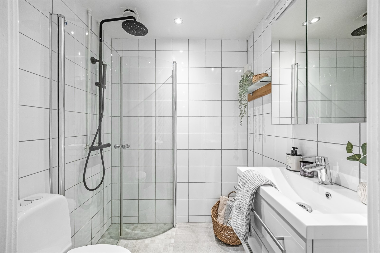 Delikat flislagt baderom med varmekabler i gulv og lysdimmer i tak. Justerbare dusjdører er satt inn for å utnytte plassen maksimalt. Opplegg for vaskemaskin. Galleribilde