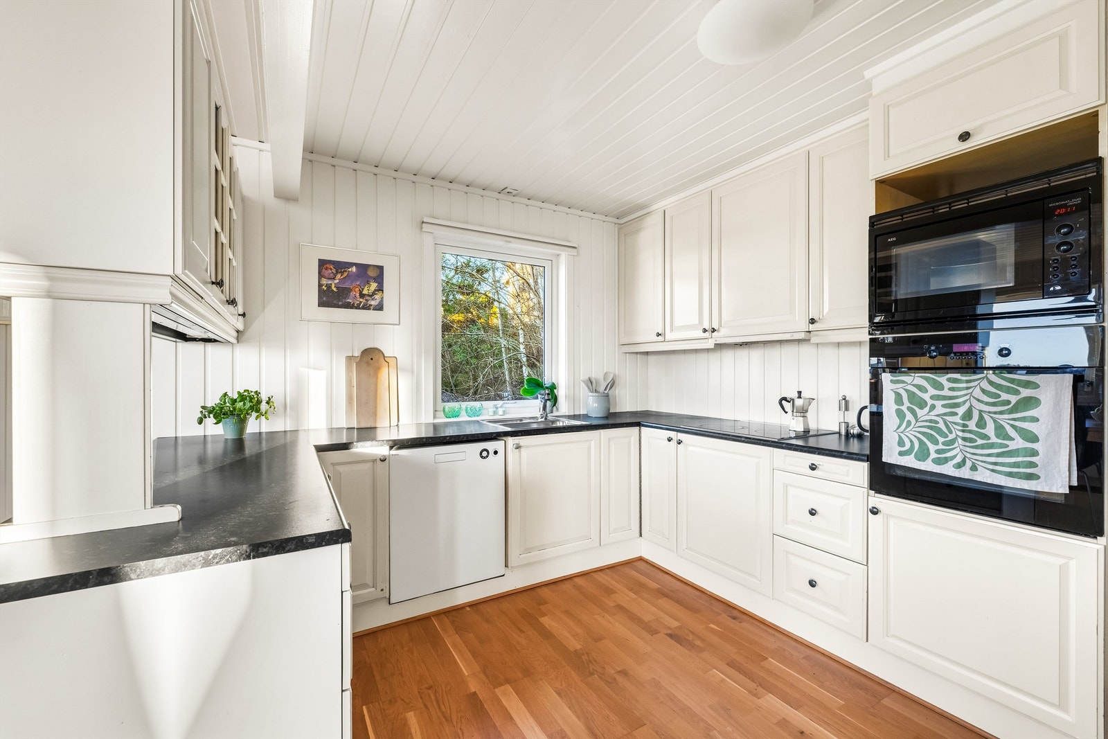 Innredning fra byggeår med hvite profilerte fronter og laminert benkeplate Galleribilde