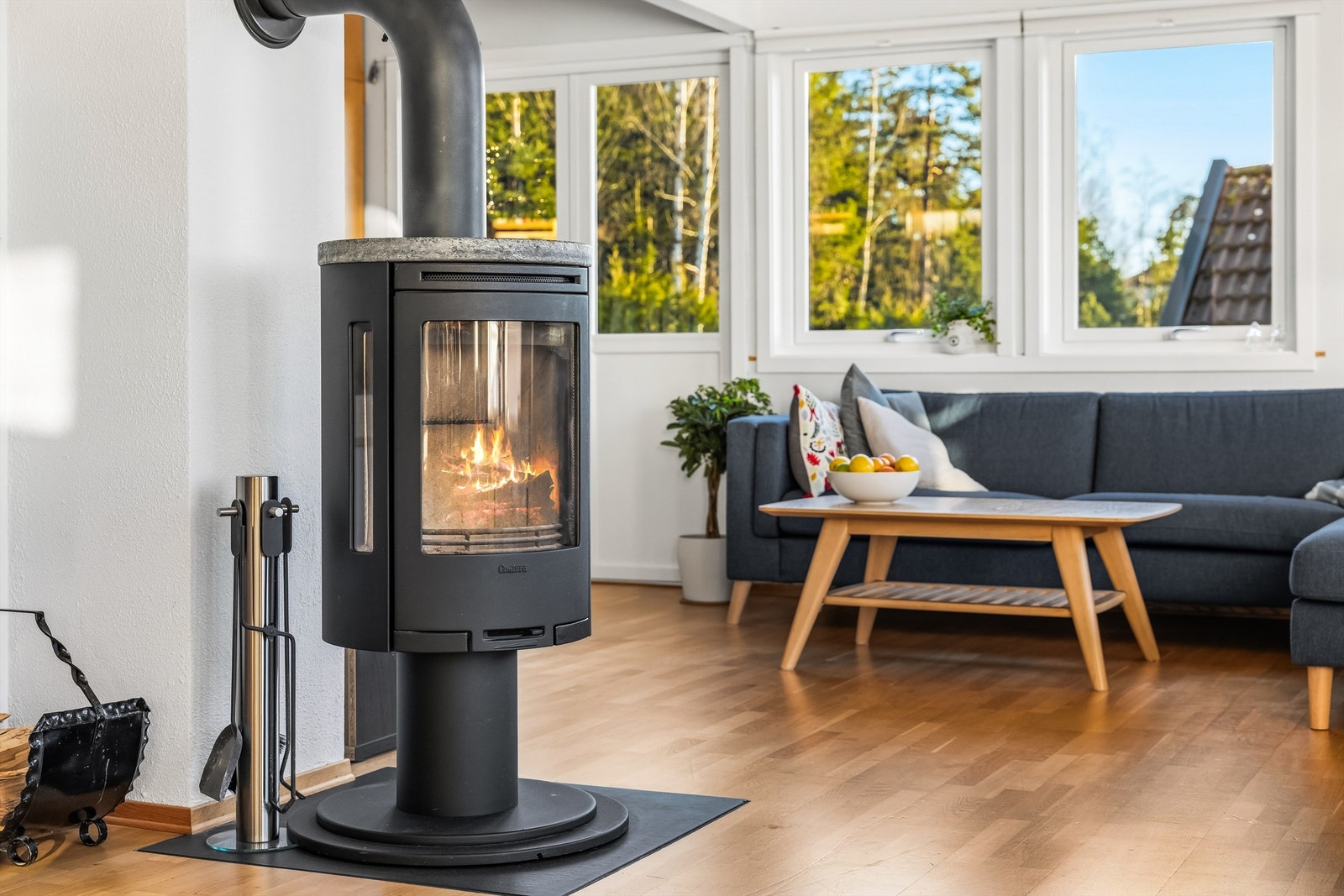 En moderne peisovn er sentralt plassert i stuen og gir behagelig varme på kjølige høst- og vinterdager. Galleribilde