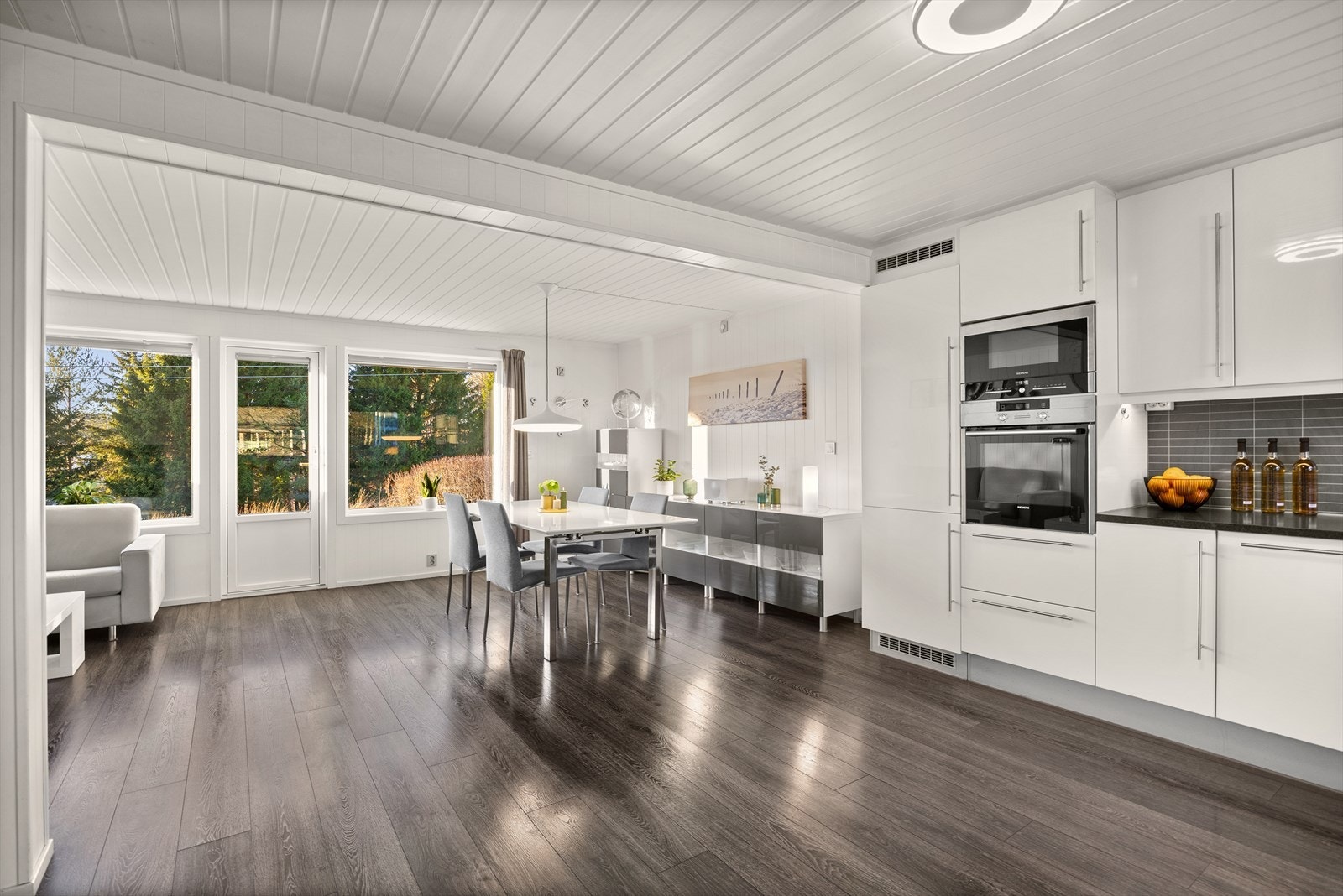 Kjøkkeninnredningen er fra 2012 og har en stilren HTH-innredning med hvite, glatte fronter og laminatbenkeplate med nedfelt kum i rustfritt stål. Galleribilde