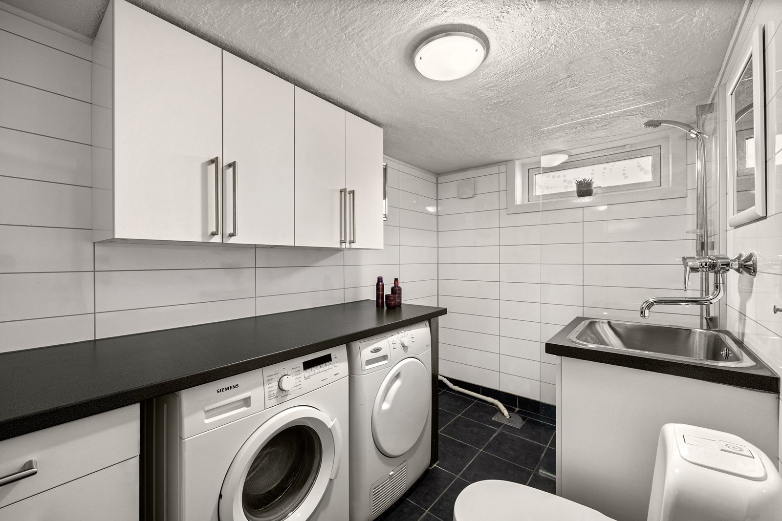 Vaskerommet (2012) har opplegg for vaskemaskin, plass til tørketrommel og behagelig gulvvarme. Rommet er utstyrt med skap med glatte fronter og laminat benkeplate, klosett og dusj med felt i herdet glass. Galleribilde