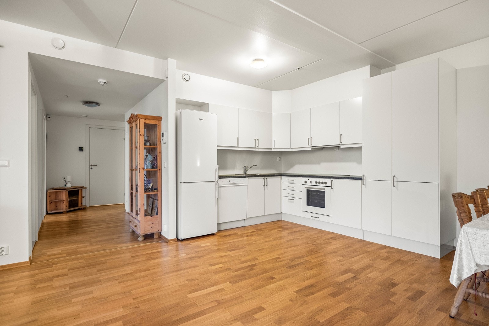 Vinklet innredning med slette fronter og laminat benkeplate. Komplett utstyrt med integrerte hvitevarer. Galleribilde