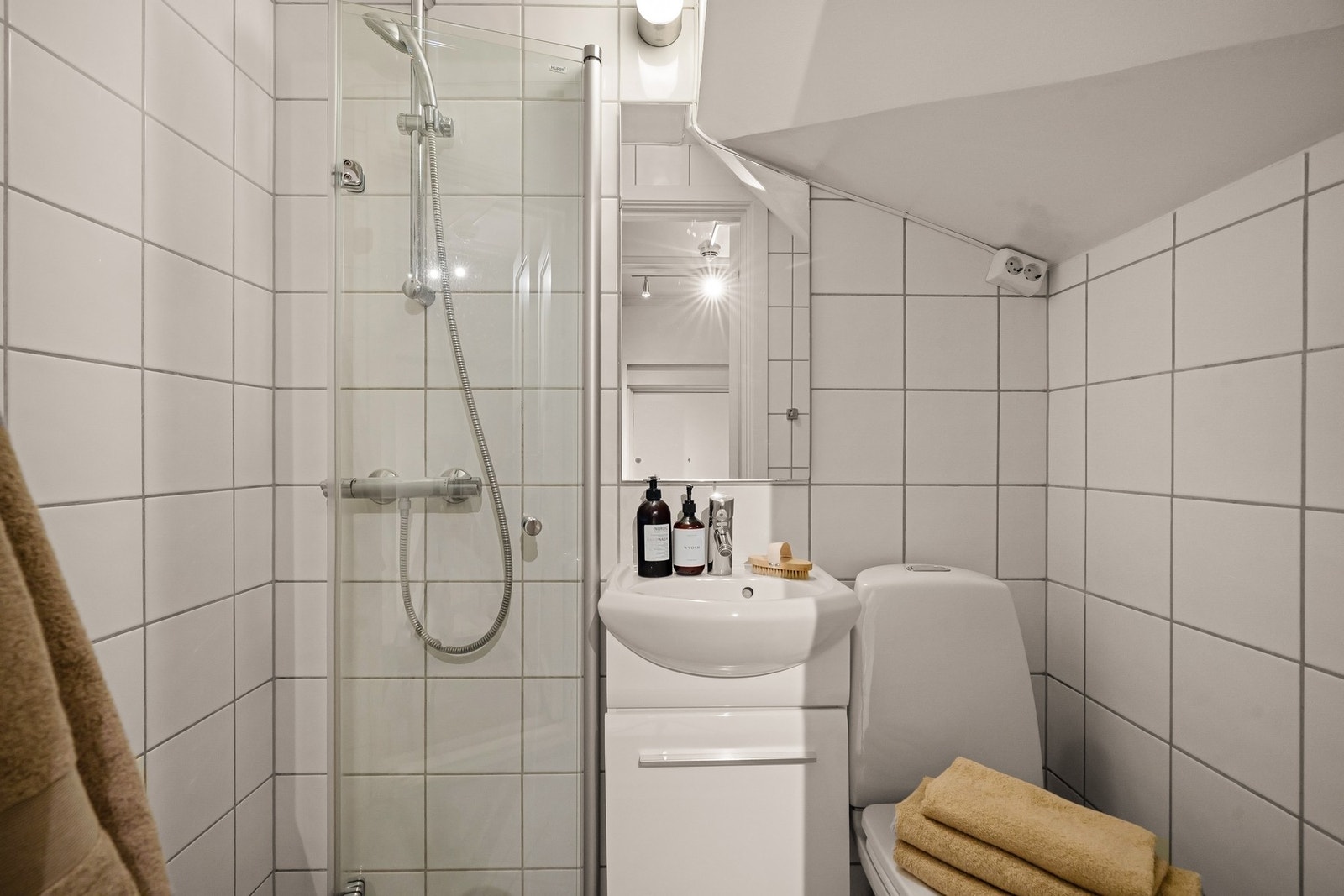 Badet er innredet med servantskap med servant, speil, toalett og dusj. Galleribilde