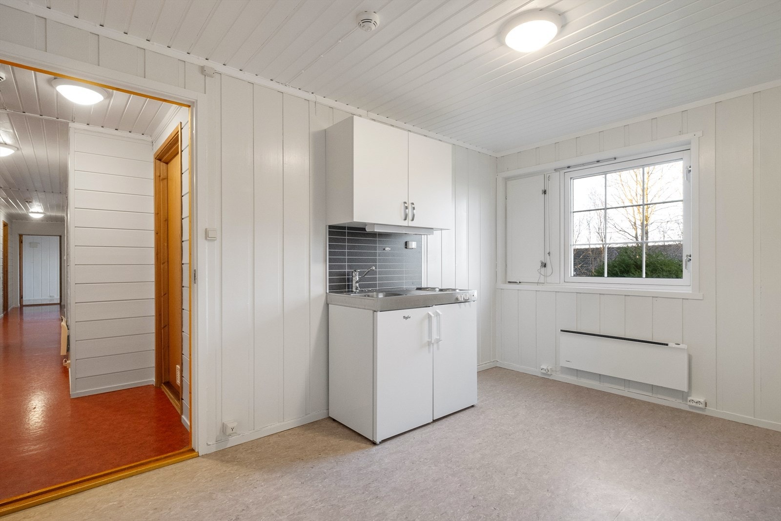 I underetasjen finnes et hybelkjøkken av nyere dato med glatte fronter og en benkeplate i stål som inkluderer vaskekum og platetopp. Galleribilde