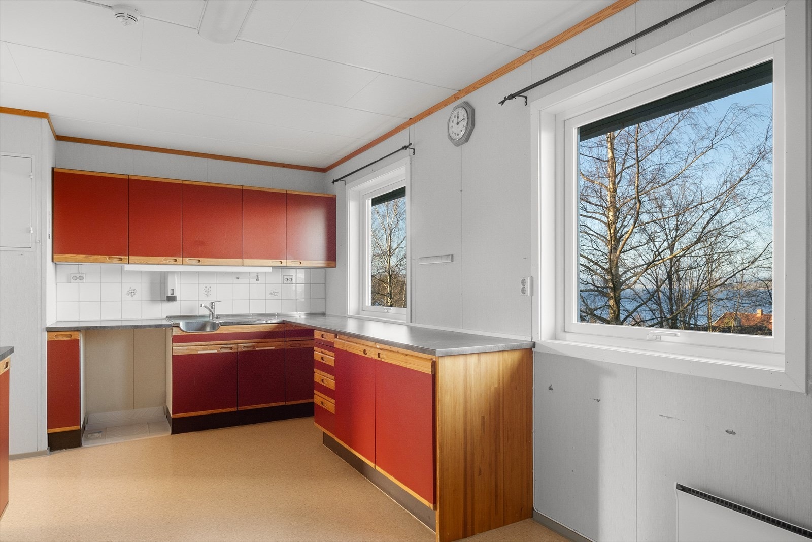 Kjøkkenet fra ca. byggeår (1987) har en innredning med slette og malte fronter, samt en laminert benkeplate med en egen modul i stål for oppvask og utslag. Galleribilde