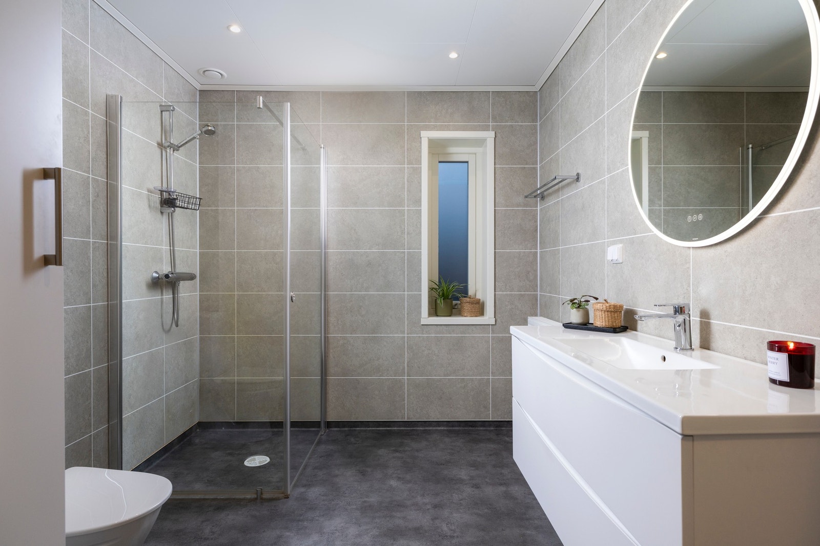 Badet i 1.etg er innredet med dusjhjørne, toalett og servant med skuffer. Galleribilde