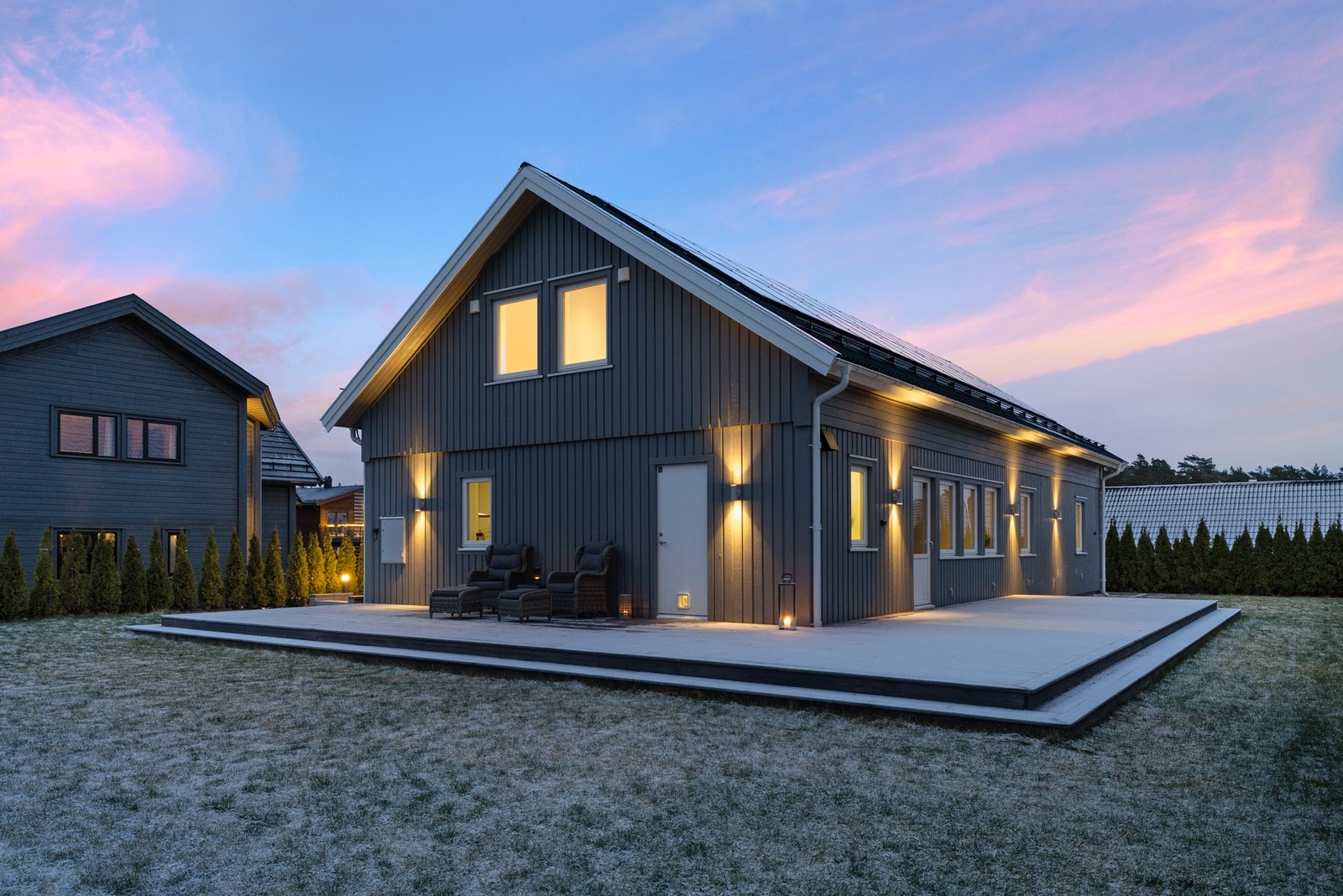 Her ser vi fasaden mot vest. Stor terrasse og direkte adgang til hage. Her er det meget solrikt, med kveldssol til nærmere kl 22 om sommeren. Galleribilde