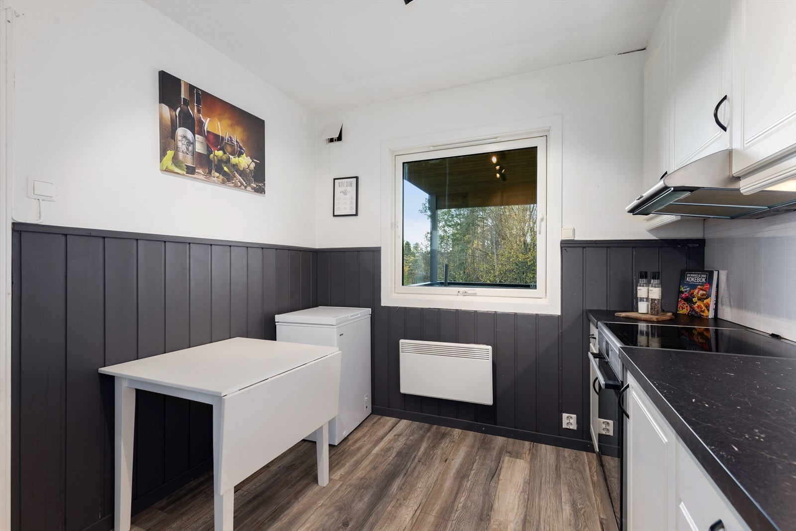 Her er det opplegg for oppvaskmaskin og avsatt plass til frittstående kjøleskap. Over kokesonen er det montert kjøkkenventilator, med avtrekk ut. Galleribilde