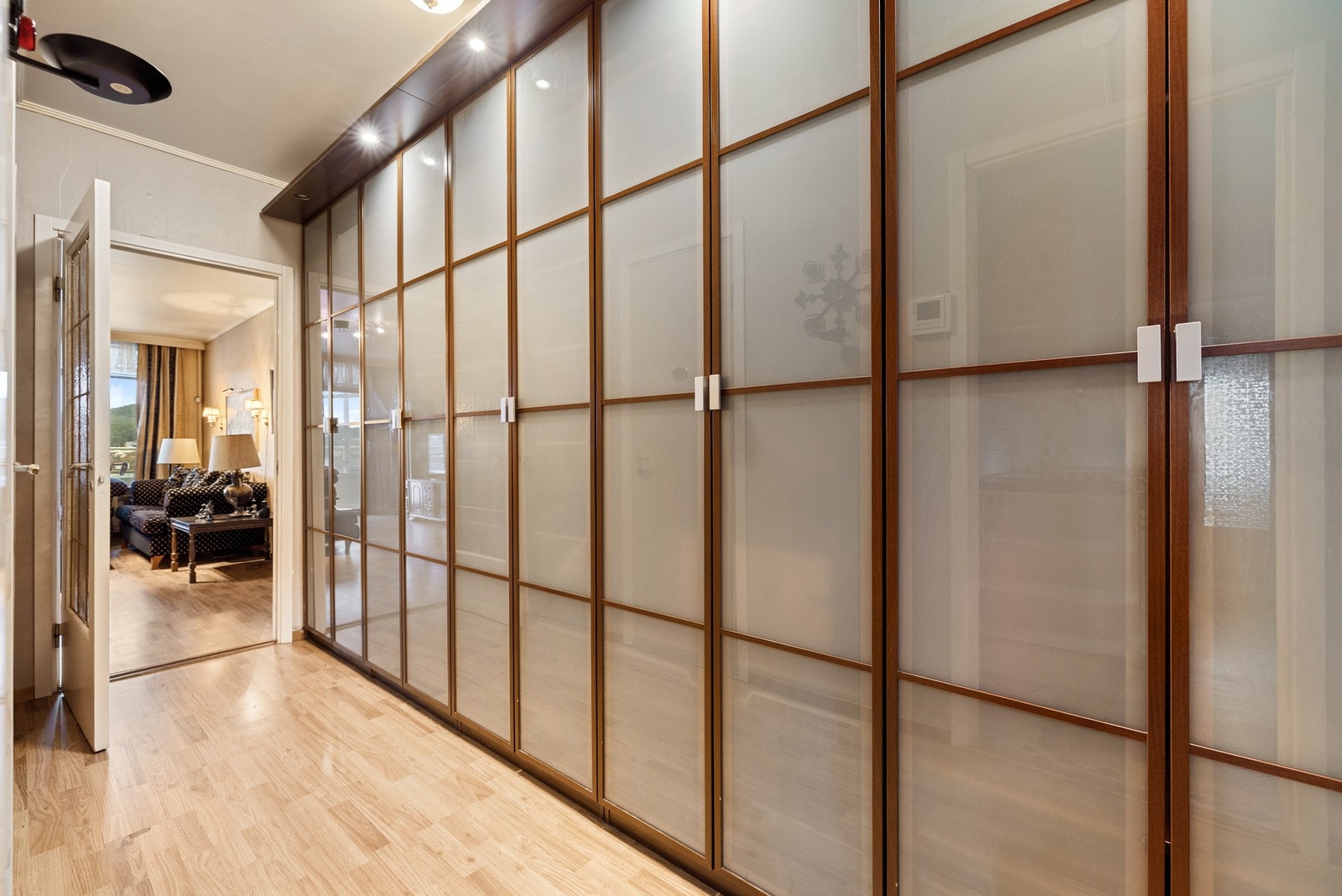 Gangen har rikelig med garderobeskap til oppbevaring. Det er fjernbetjent porttelefon med kamera, slik at hoveddøren nede kan åpnes fra leiligheten - når gjester kommer på besøk. Galleribilde