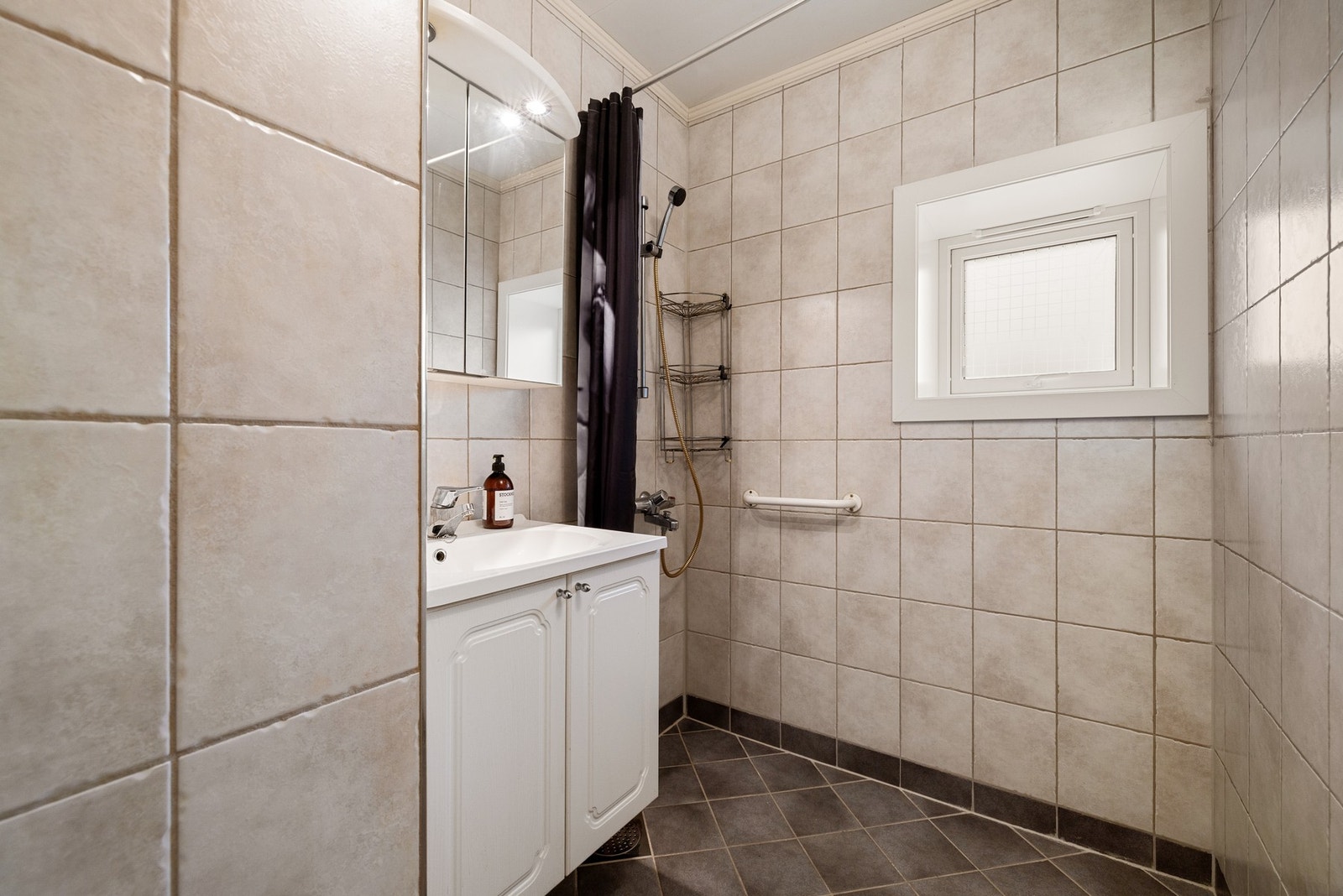 Helfliset baderom med gulvvarme og klassisk, hvit baderomsinnredning med speil i overkant. Galleribilde