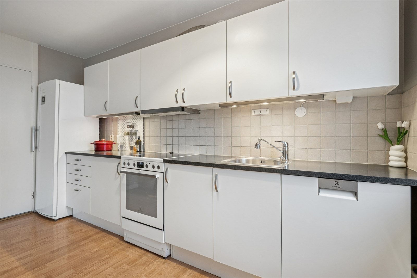 Kjøkkenet har en moderne innredning fra HTH med glatte fronter og laminat benkeplate. Galleribilde