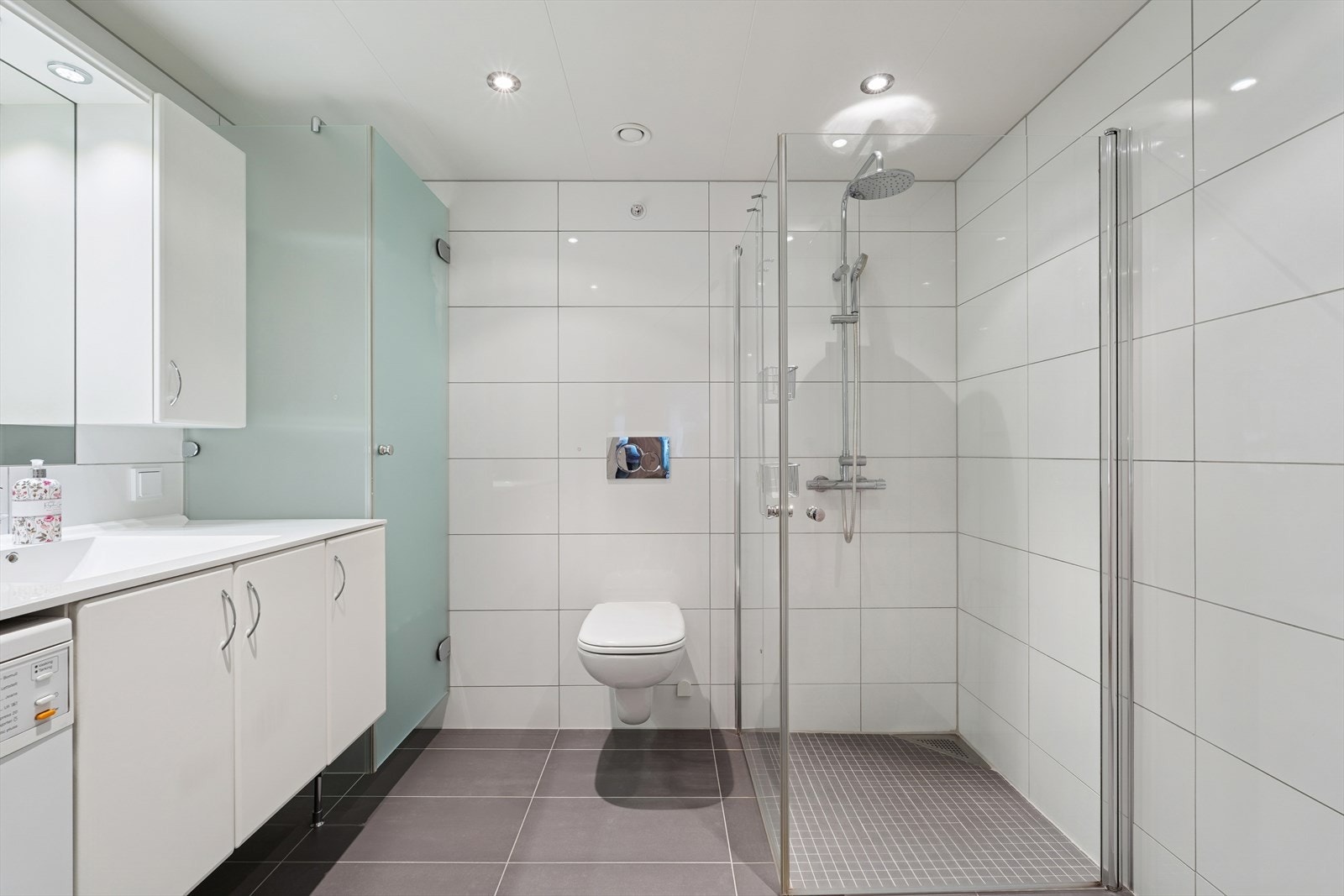 Baderom med tørkeskap og opplegg for vaskemaskin Galleribilde