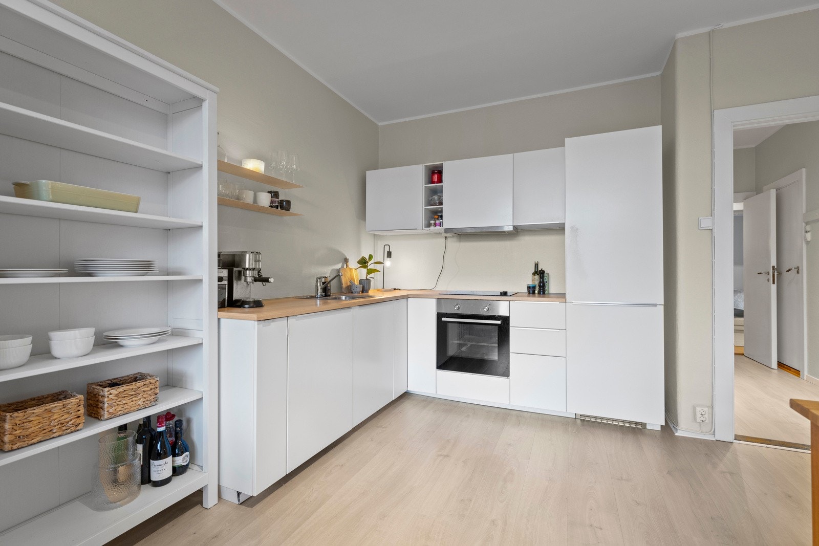 Kjøkkeninnredningen er utført i en praktisk L form og har glatte laminatfronter. Galleribilde