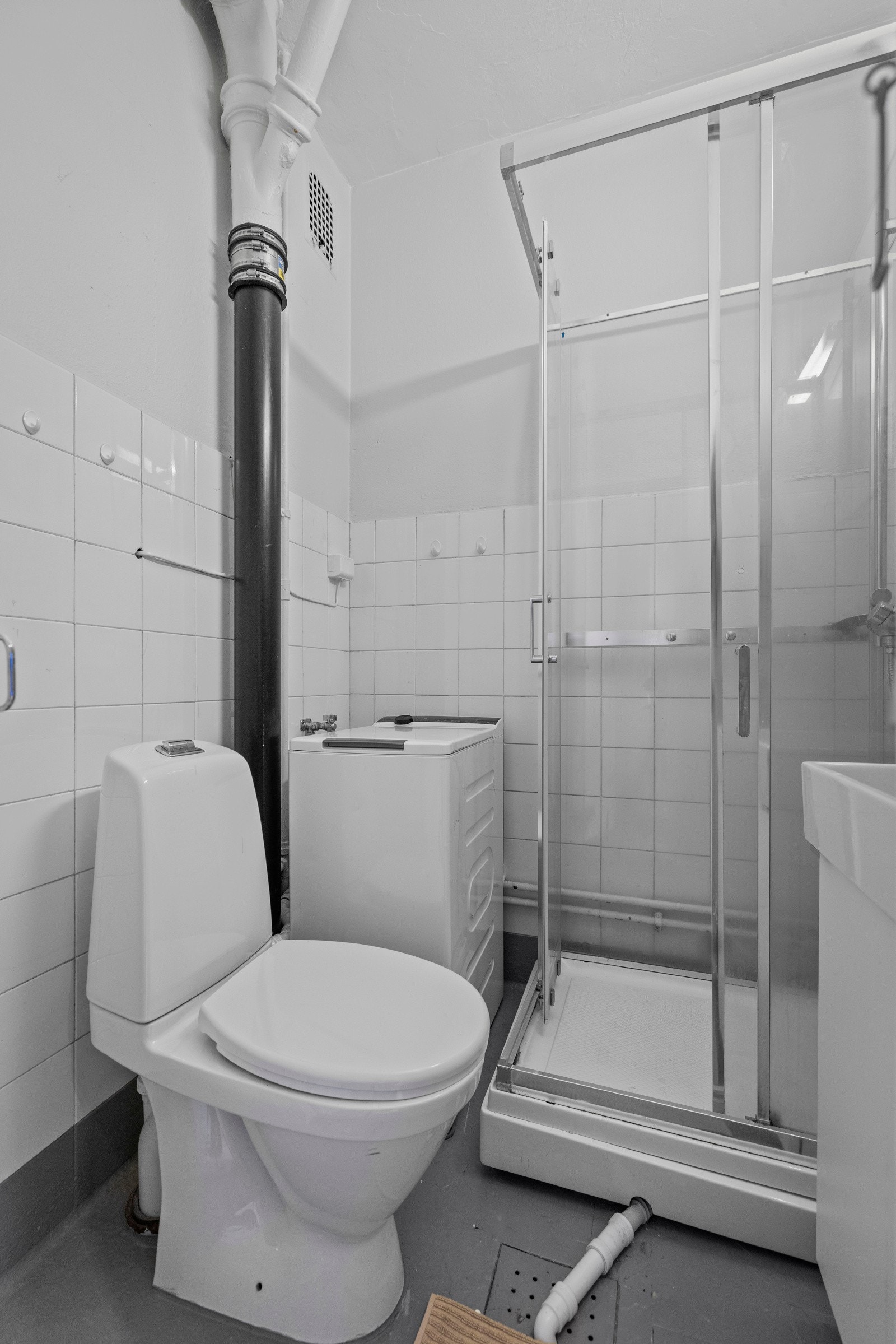Baderom trolig fra byggeår. Baderominnredningen består av servantskap, gulvstående toalett og dusjkabinett. Badet har naturlig ventilering samt opplegg for vaskemaskin. Galleribilde
