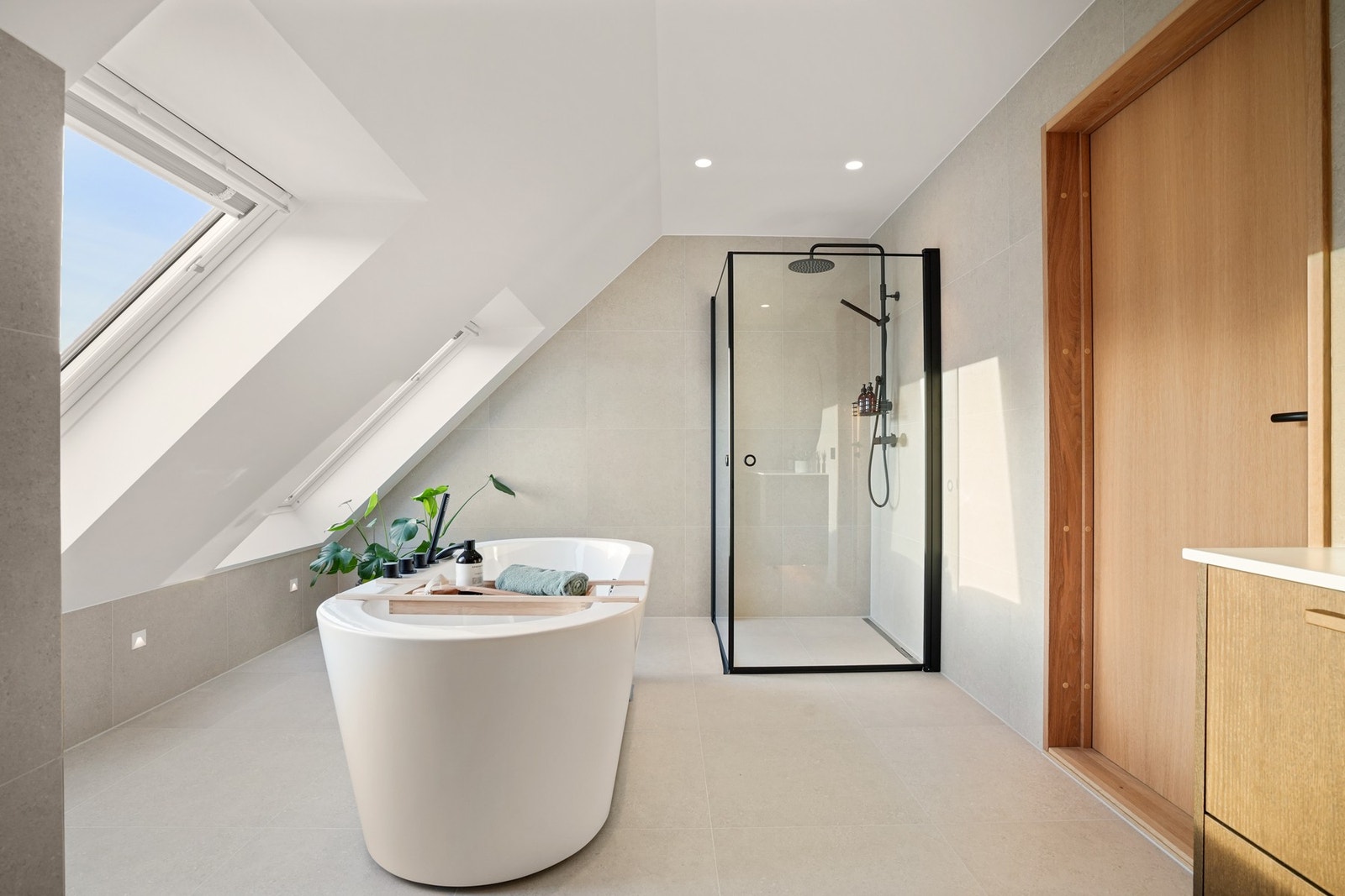 I tillegg til det flotte badekaret har badet et stilrent dusjhjørne med regnfallsdusj og innfellbare glassdører. Galleribilde