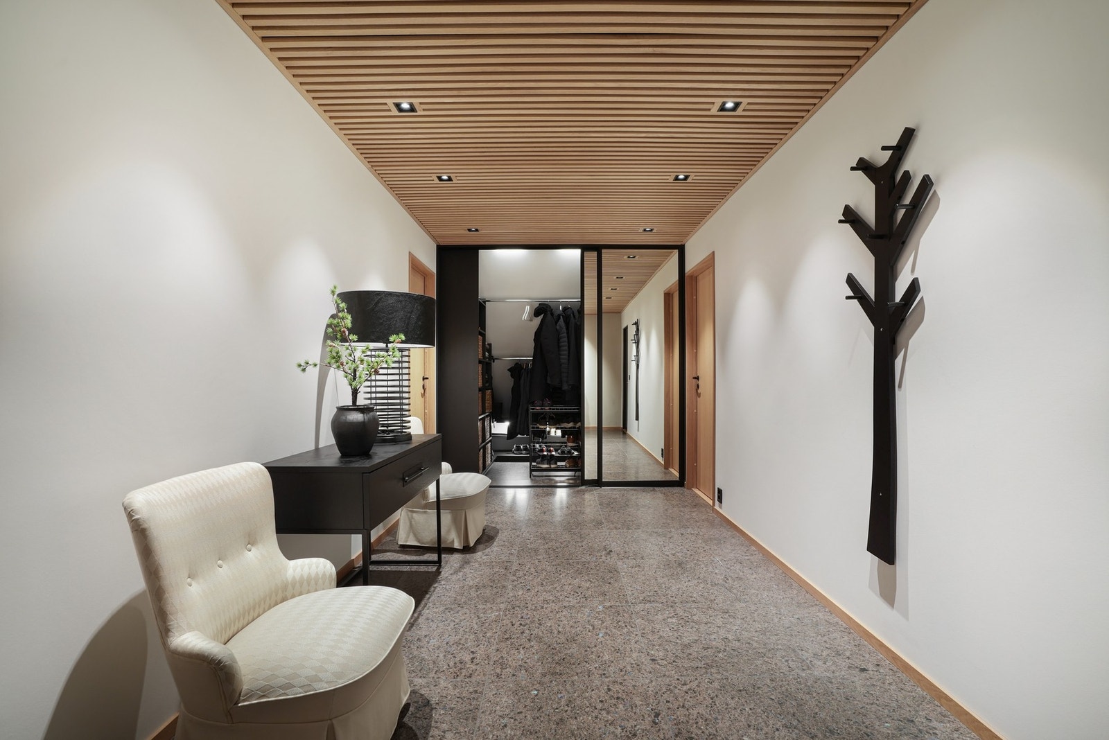 Entreen har en skyvedørsgarderobe langs kortveggen, med klesoppheng på to rekker og plassbygde hyller tilpasset rommet. Galleribilde