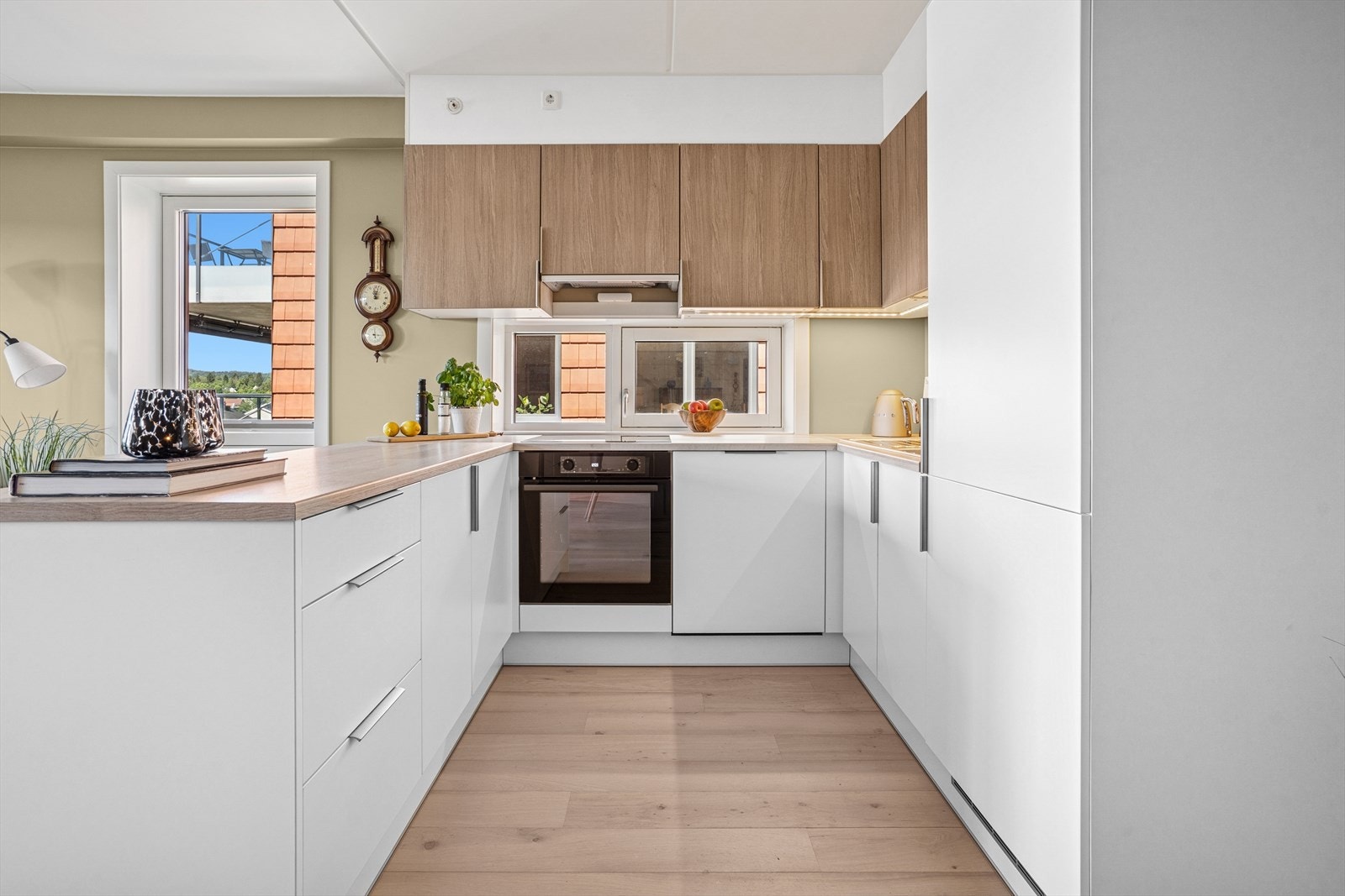 Moderne og stilren kjøkkenløsning med hvite glatte fronter og en trefarget benkeplate av laminat Galleribilde