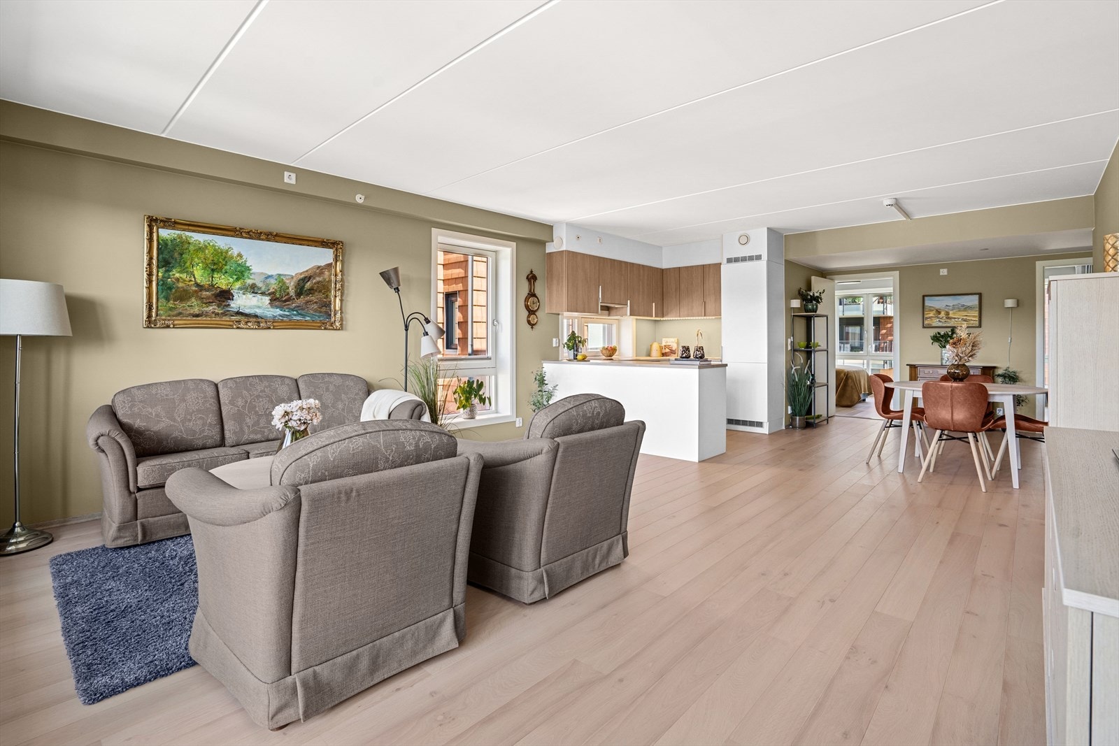 Romslig stue med flere møbleringssoner for både sofakrok og spisestue Galleribilde