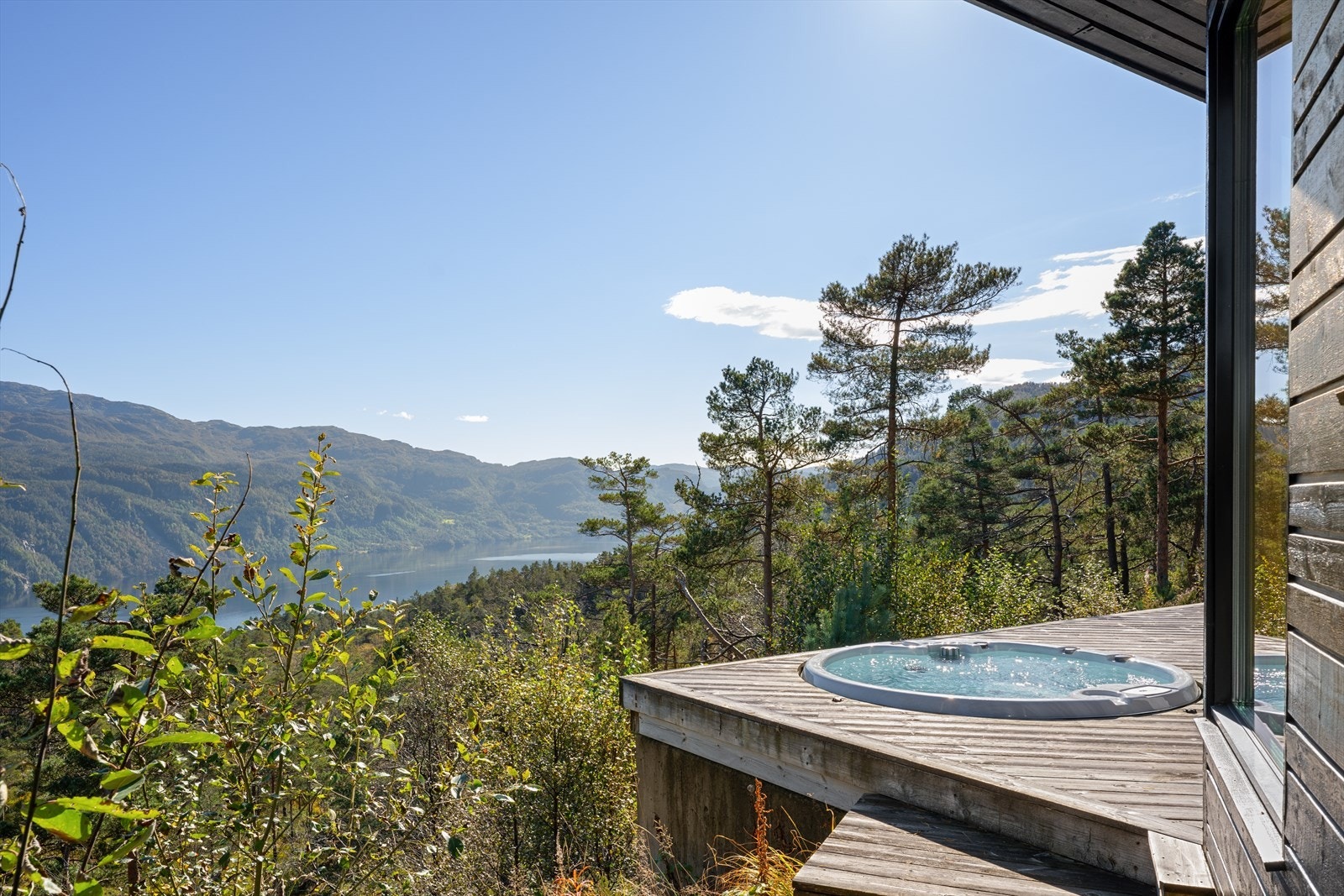 Her sitter man skjermet og nyter den flotte utsikten i et vakkert landskap mot fjord og fjell. Galleribilde