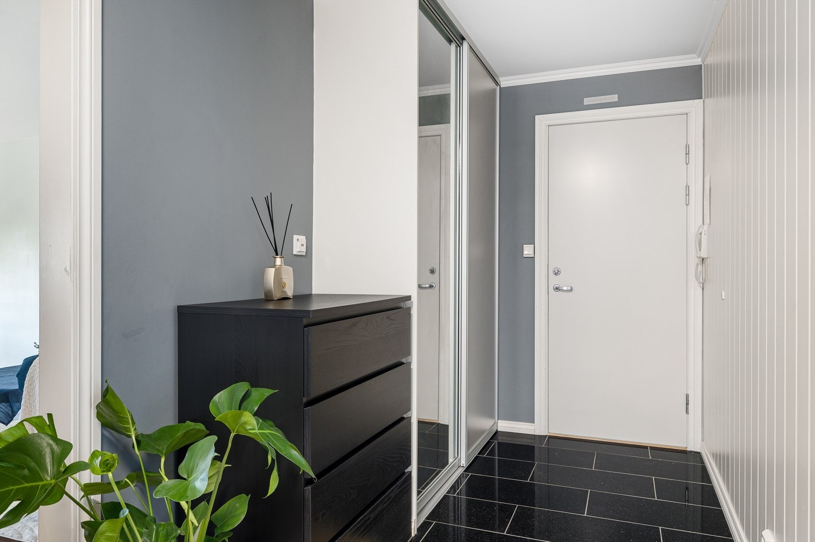 Entréen har flislagt gulv med behagelig gulvvarme - perfekt for kalde dager og enkel rengjøring. Her finner du også en romslig skyvedørsgarderobe som gir god oppbevaringsplass til yttertøy og sko. Galleribilde