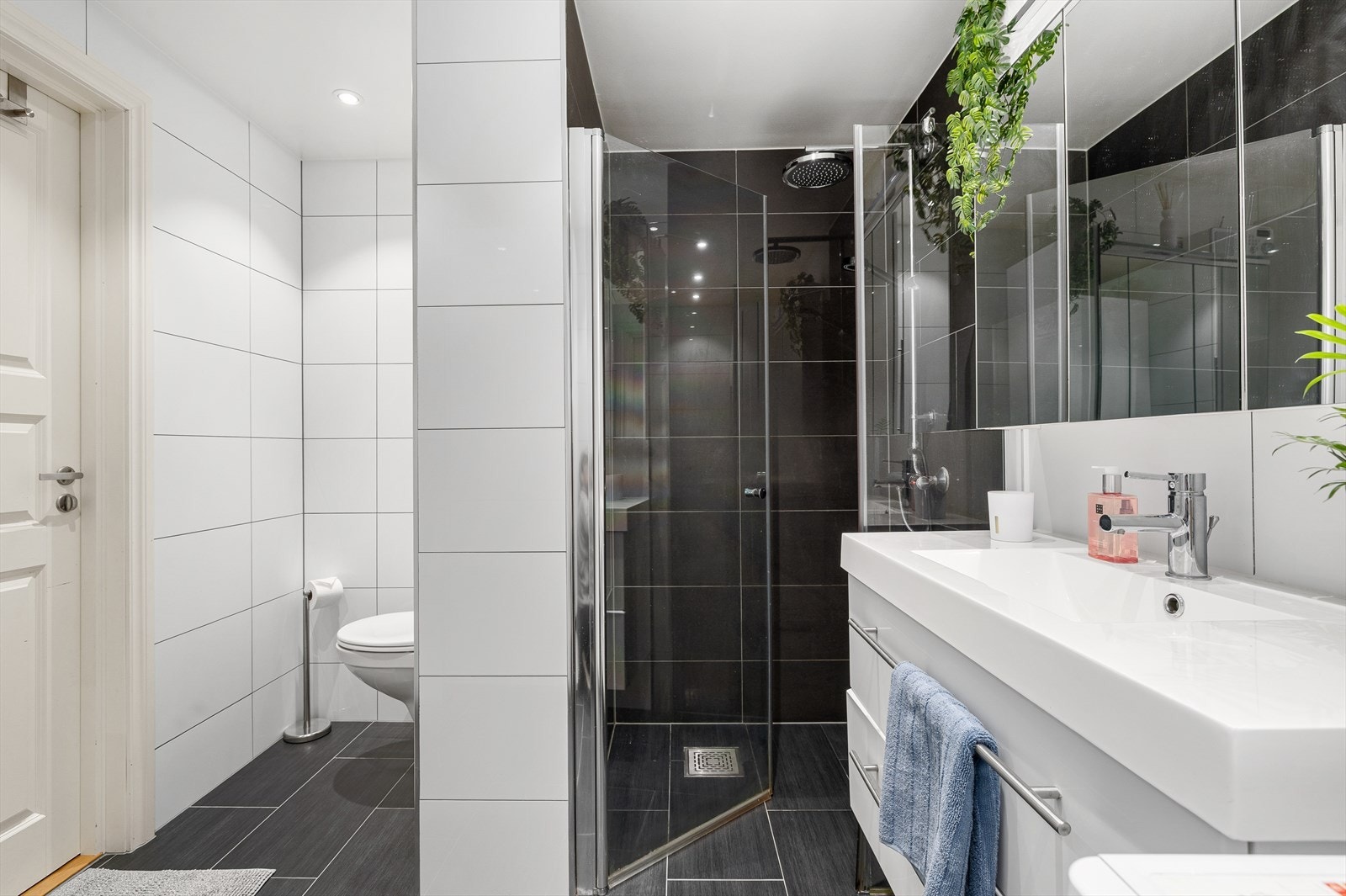 Badet fremstår som nydelig og innbydende, med flislagte overflater som gir et eksklusivt preg. Gulvvarme sørger for behagelig temperatur året rundt, og downlights i himlingen gir et jevnt og stemningsfullt lys. Galleribilde