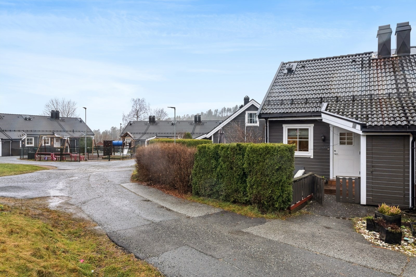 Pent opparbeidet fellestomt i borettslaget med asfalterte internveier, lekeplass, plenarealer, trær og annen beplantning. Galleribilde