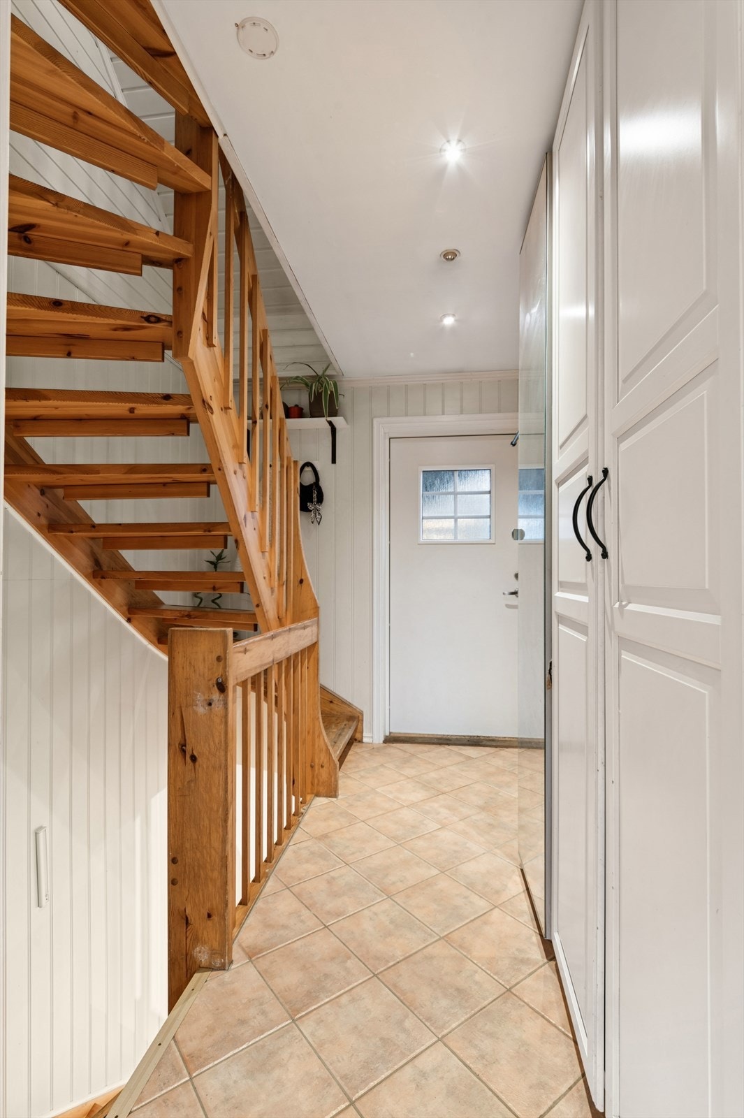 Flislagt entré med plass til oppbevaring i garberobeskap. Galleribilde