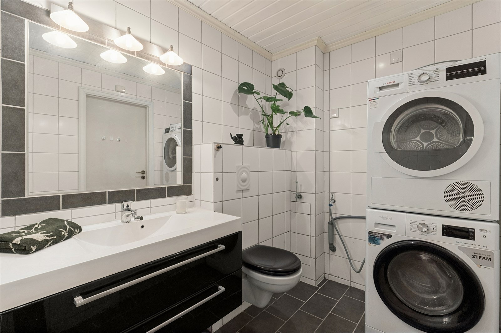 Baderommet har fliser på vegg og gulv og malt panel i himling. Galleribilde