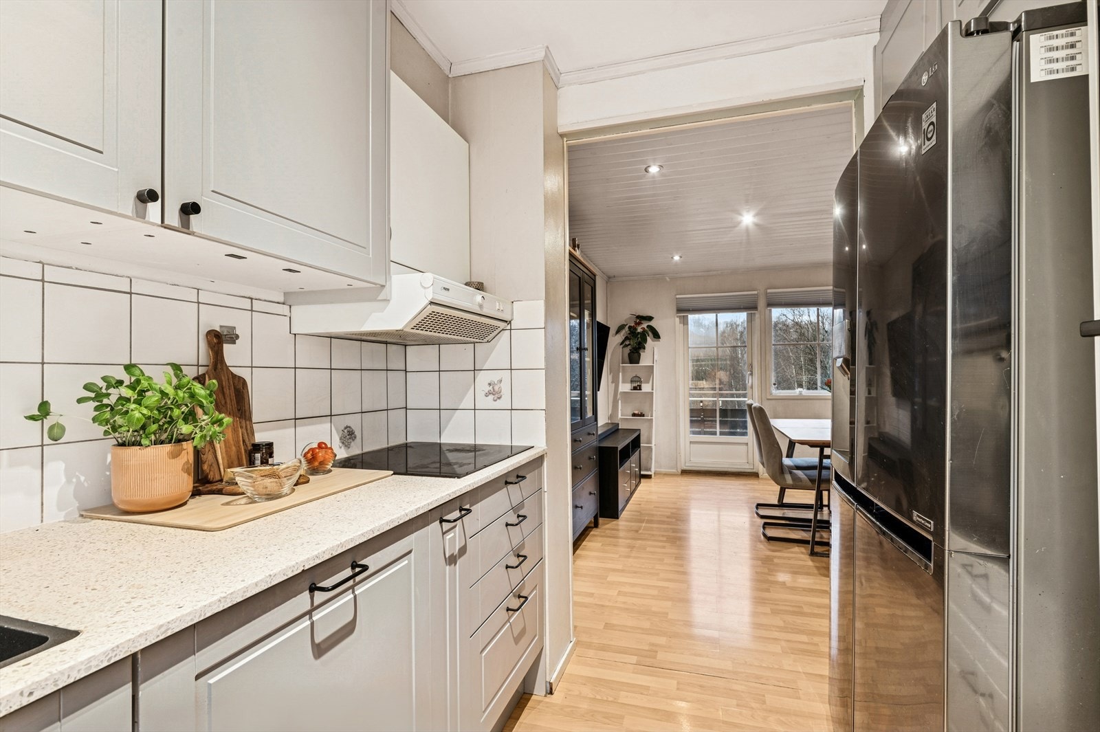 Lys kjøkkeninnredning med profilerte flater. Galleribilde