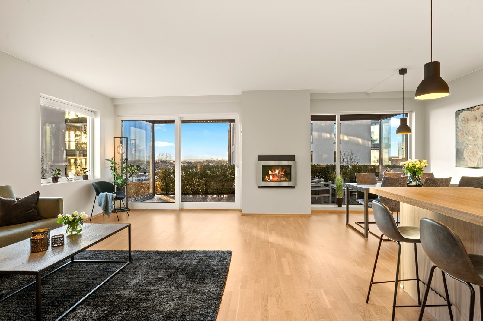 Store vindusflater og skyvedør i malt tre gir rikelig med lys og direkte tilgang til uteplassen. Galleribilde